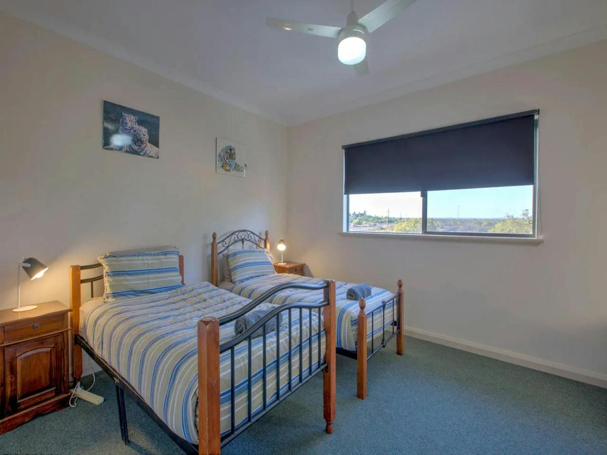 Comfortable twin bedroom with ceiling fan and peaceful landscape views