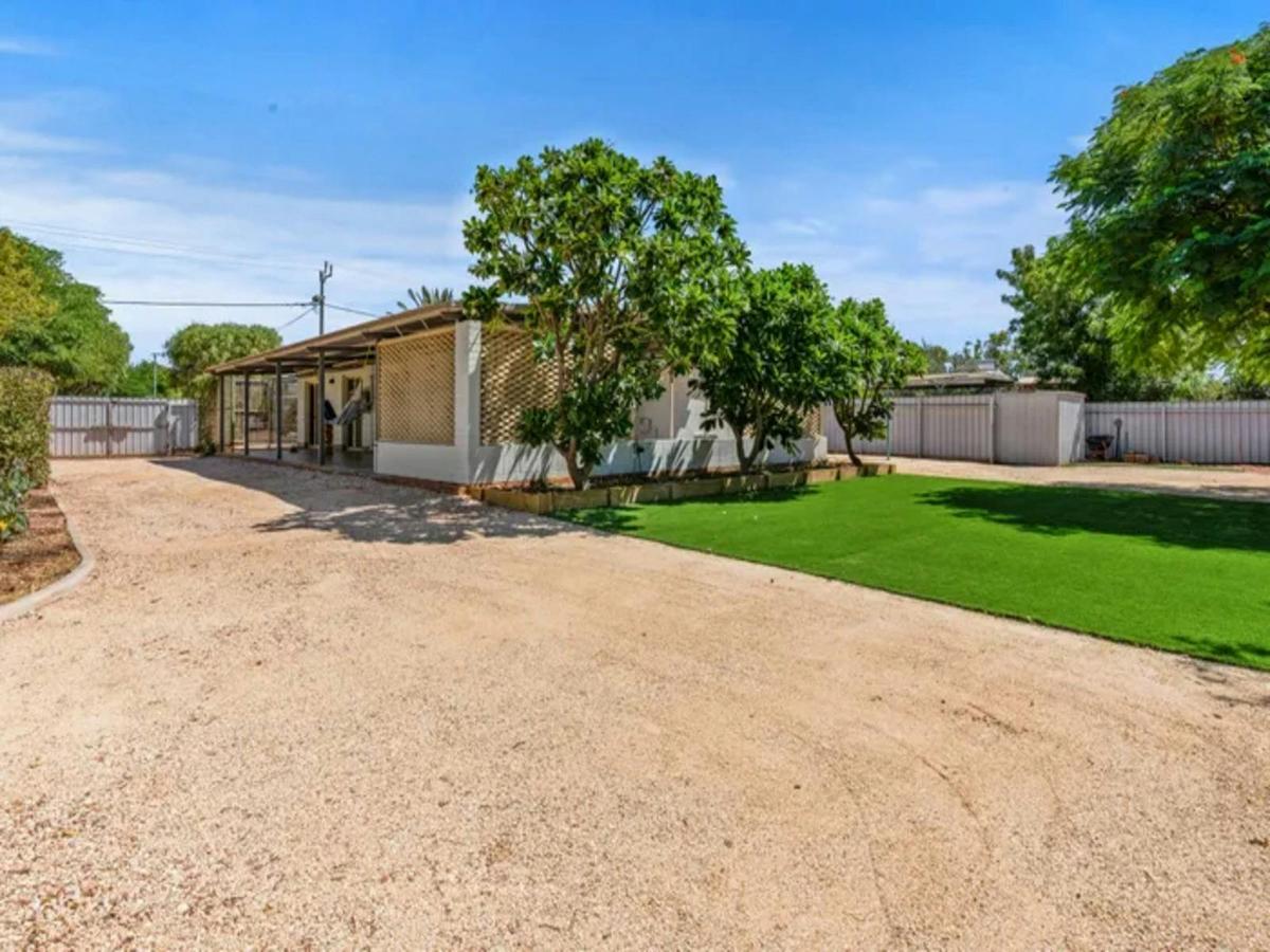 Spacious holiday home exterior with ample parking and a large green yard.