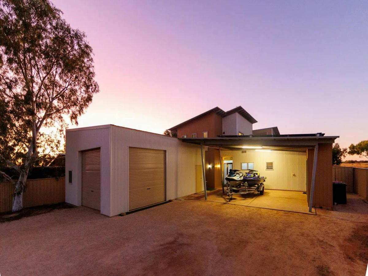 Large garage and covered carport offering plenty of space for vehicles and gear