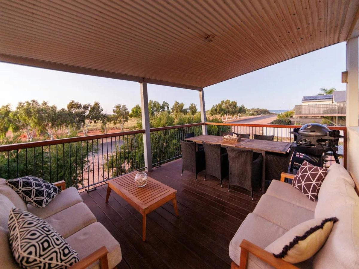 Spacious covered deck with outdoor dining, lounge seating and a barbecue