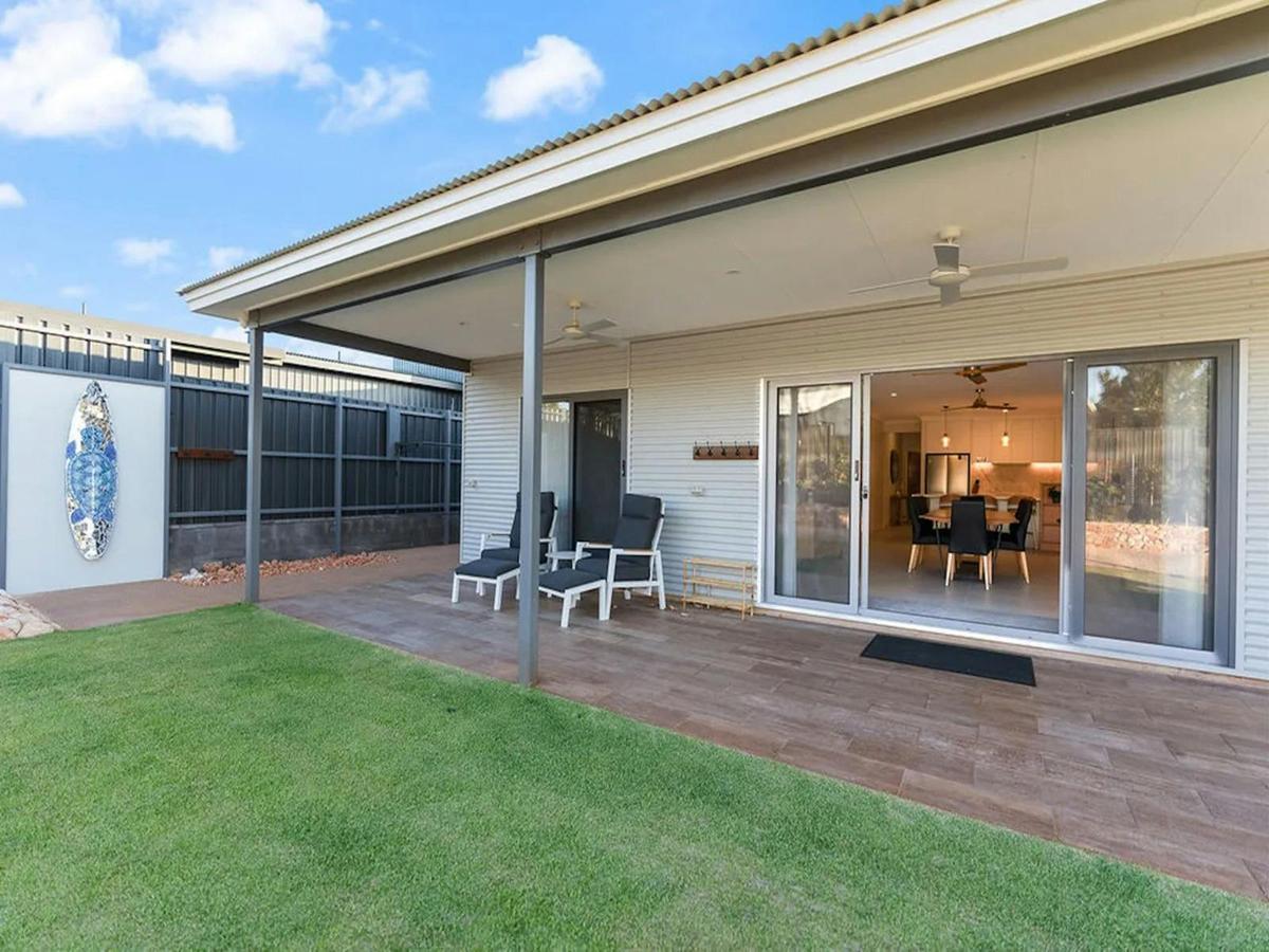Covered back patio with lounge seating and direct access to the spacious yard