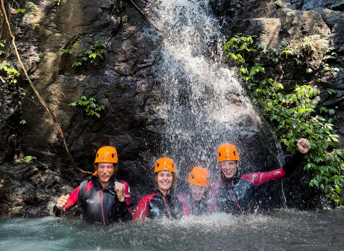 Cooling off beneath a waterfall during a guided canyoning adventure on the Coffs Coast.