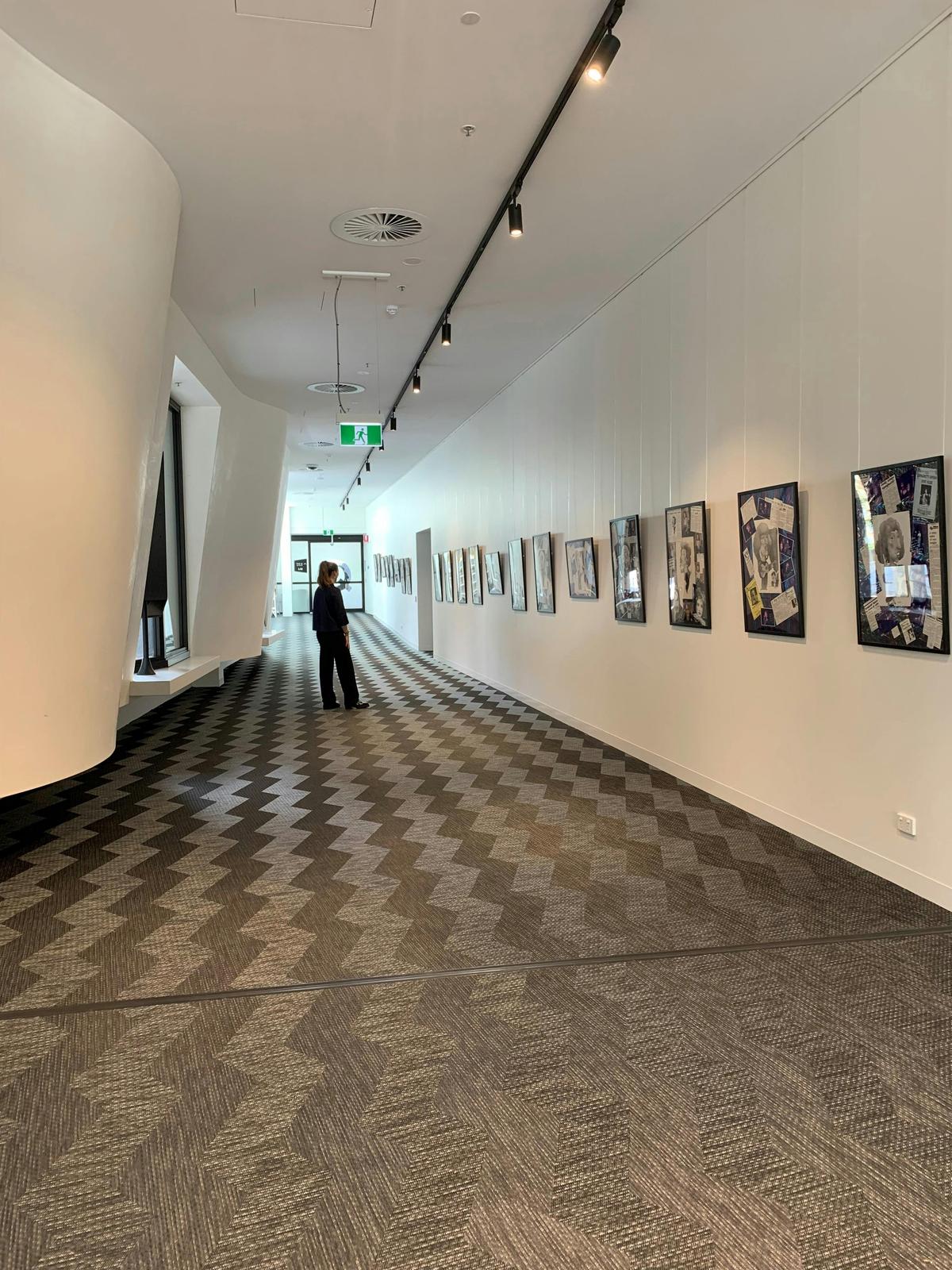 Interior gallery photo looking west with person in mid ground h per