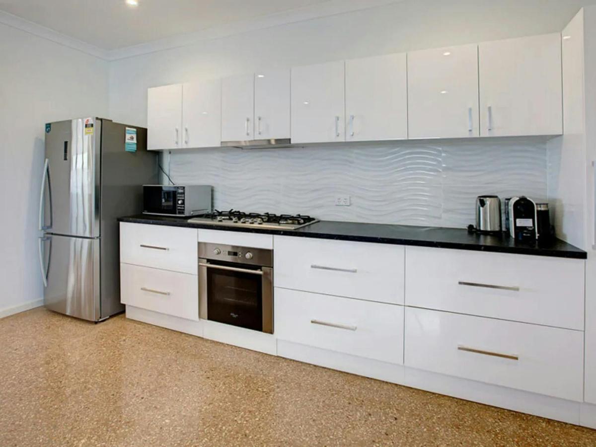 The modern kitchen offers abundant cabinetry, stainless appliances, and generous workspace