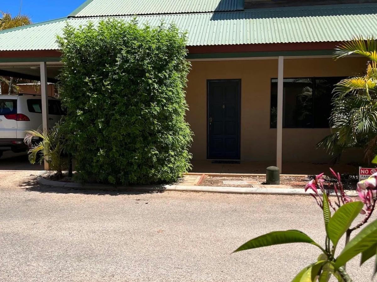 The welcoming exterior is surrounded by tropical landscaping in a peaceful setting