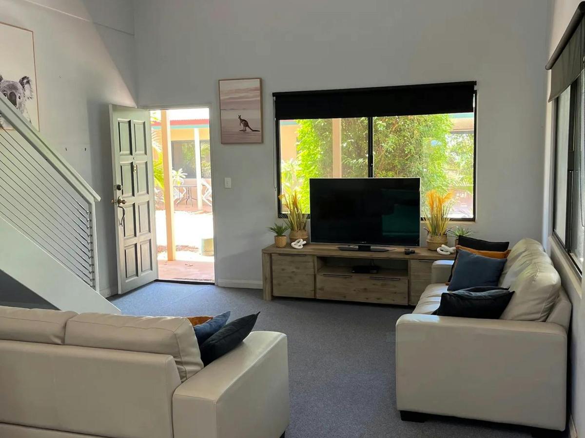 The inviting living room provides comfortable seating, natural light, and easy patio access
