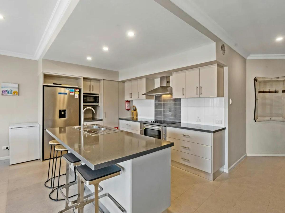 The modern kitchen features a large island, generous storage, and quality appliances