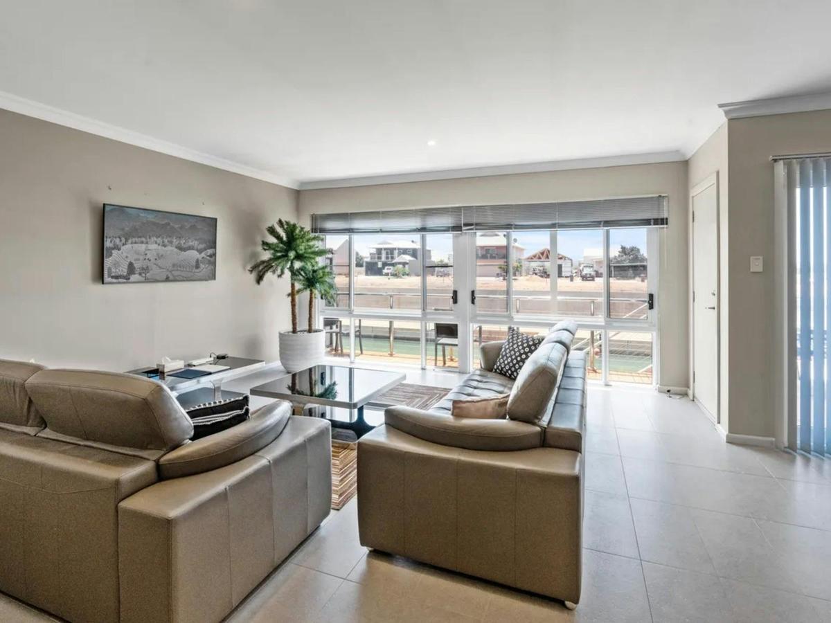 The bright living room offers generous seating and wide windows overlooking the waterfront