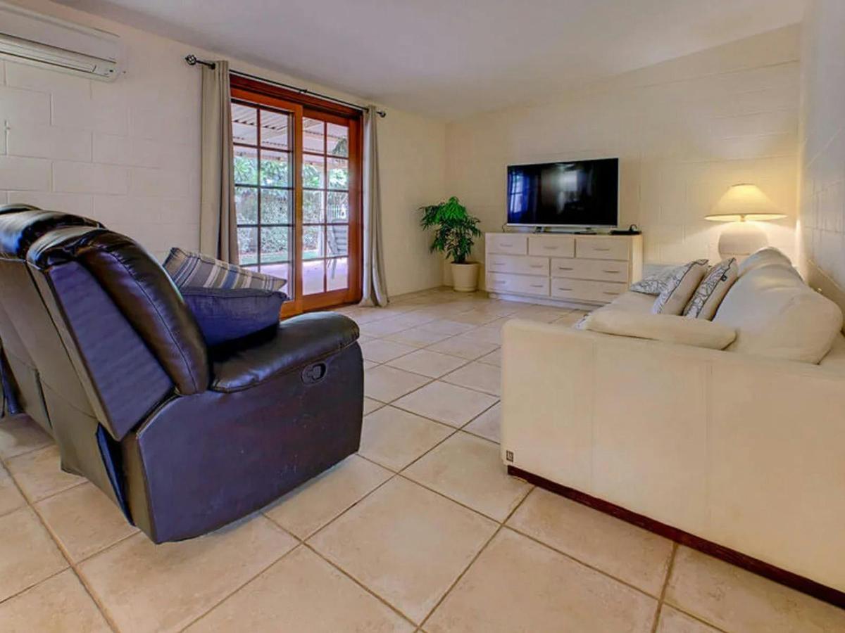The spacious living room features comfortable seating, a television, and easy patio access