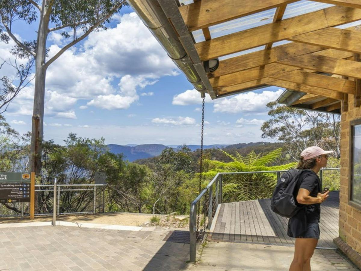 A person reads signage at the start of the Valley of the Waters track in Blue Mountains National