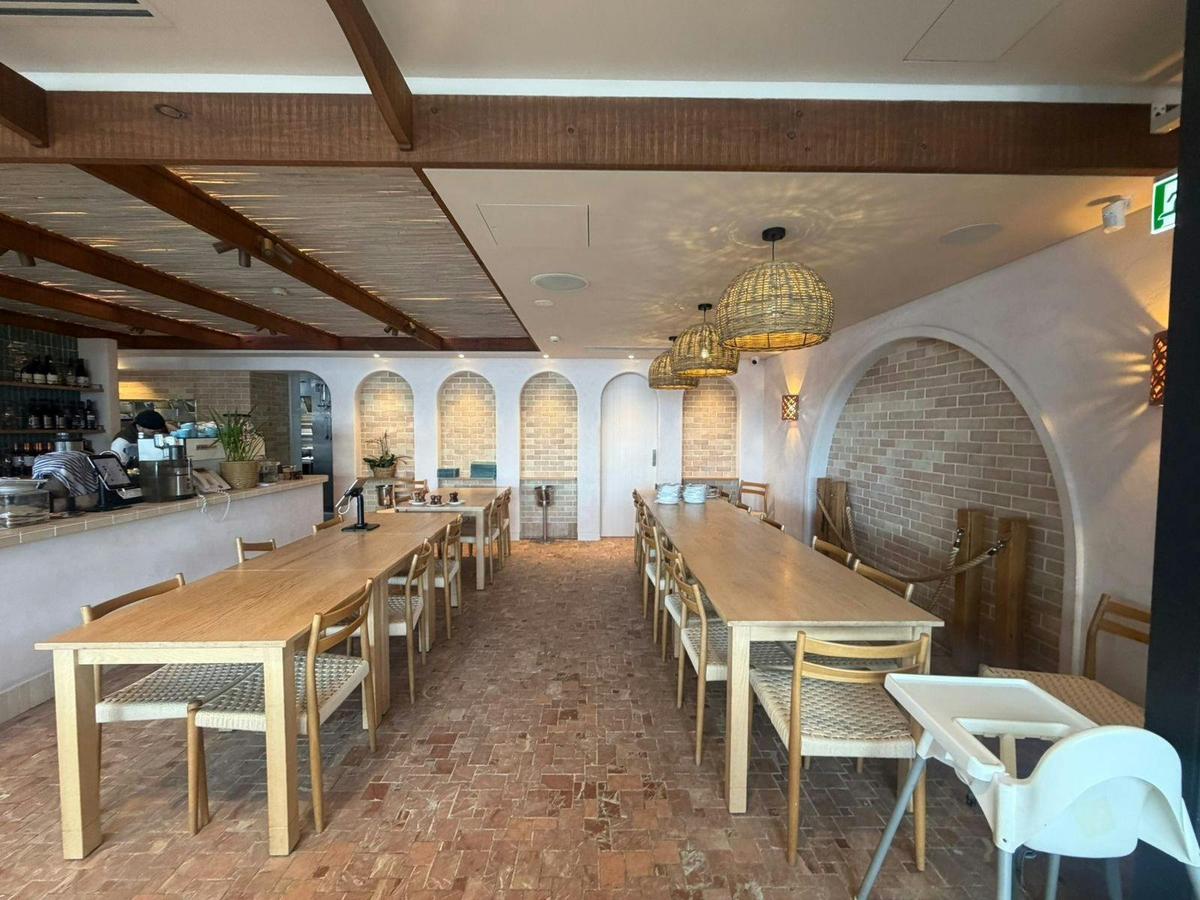 The dining room opens to the counter and kitchen beside brick arch alcoves.