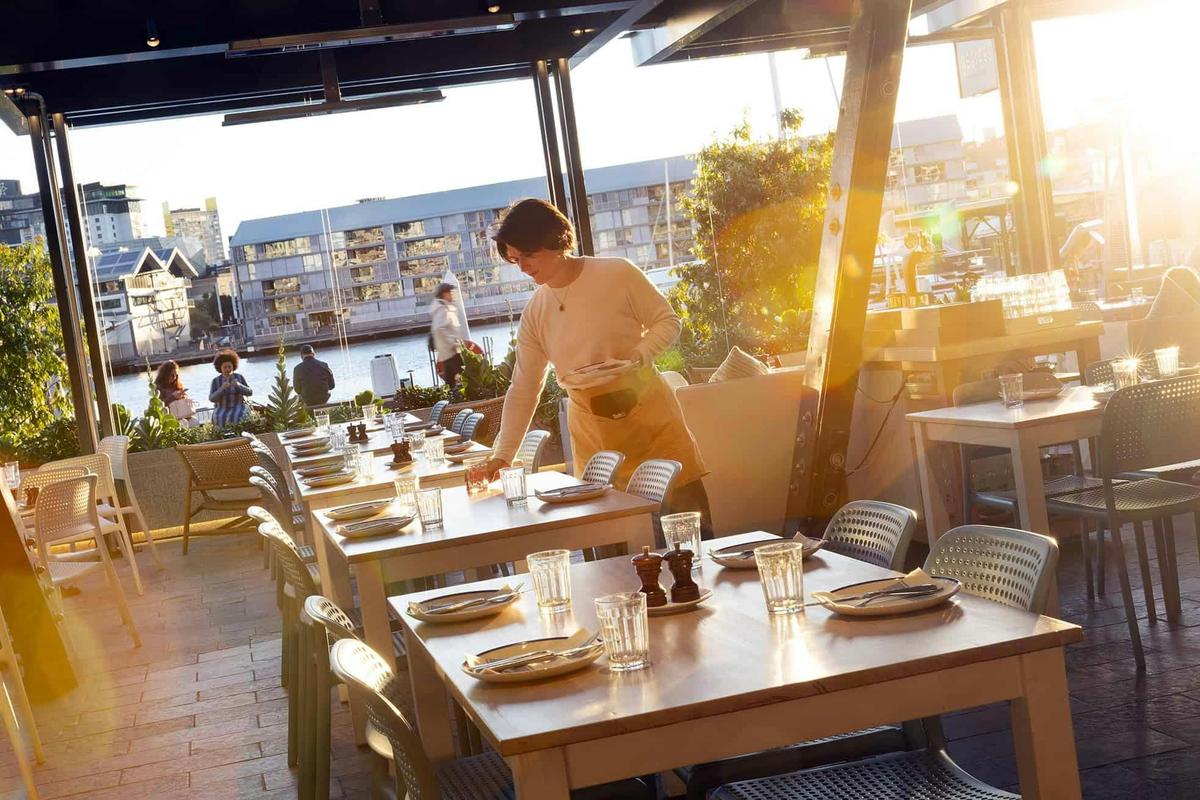 The covered terrace looks over the promenade and the water at King Street Wharf.
