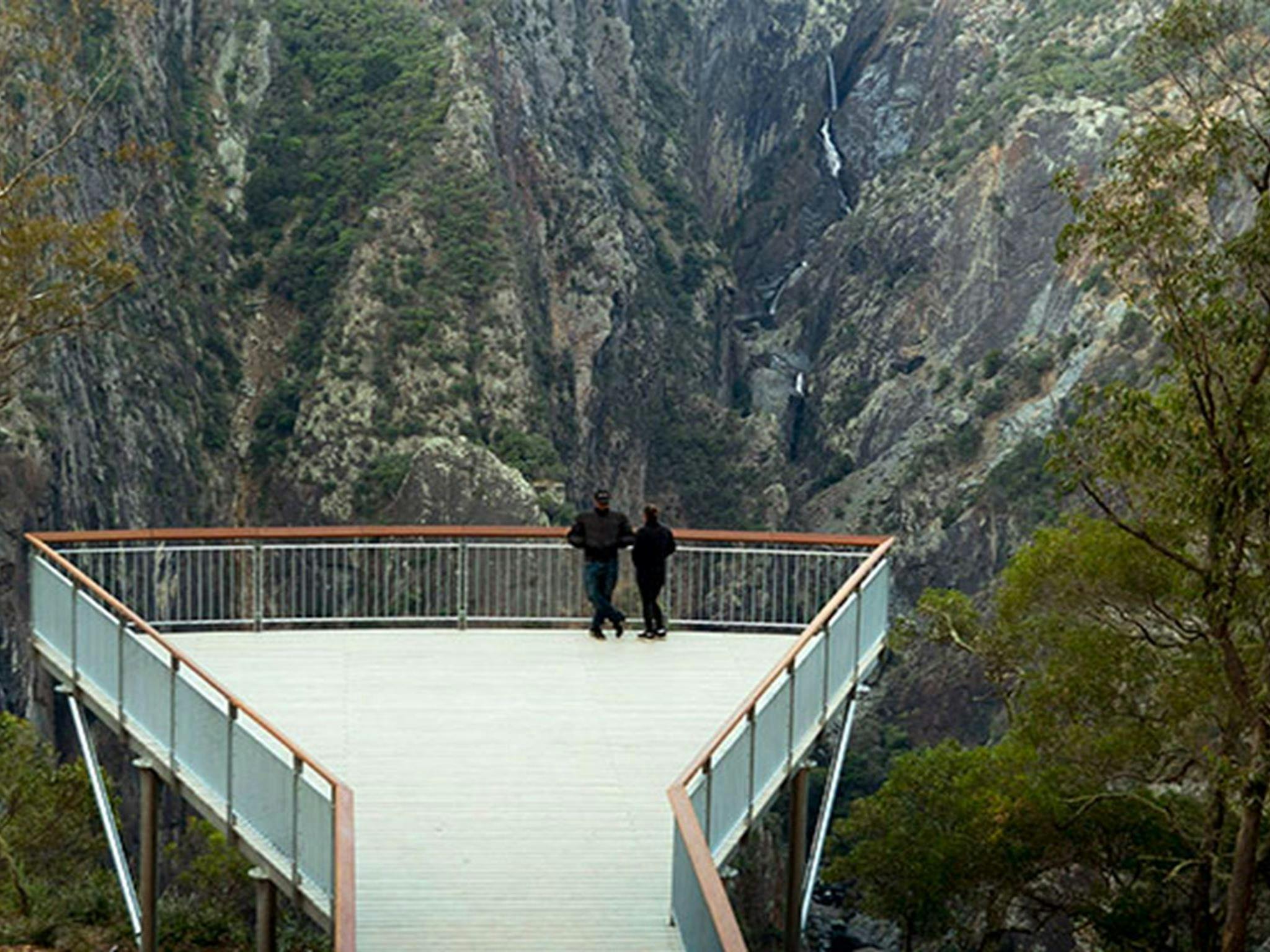 2 people view Wollomombi Falls from the wheelchair-accessible lookout platform in Oxley Wild Rivers