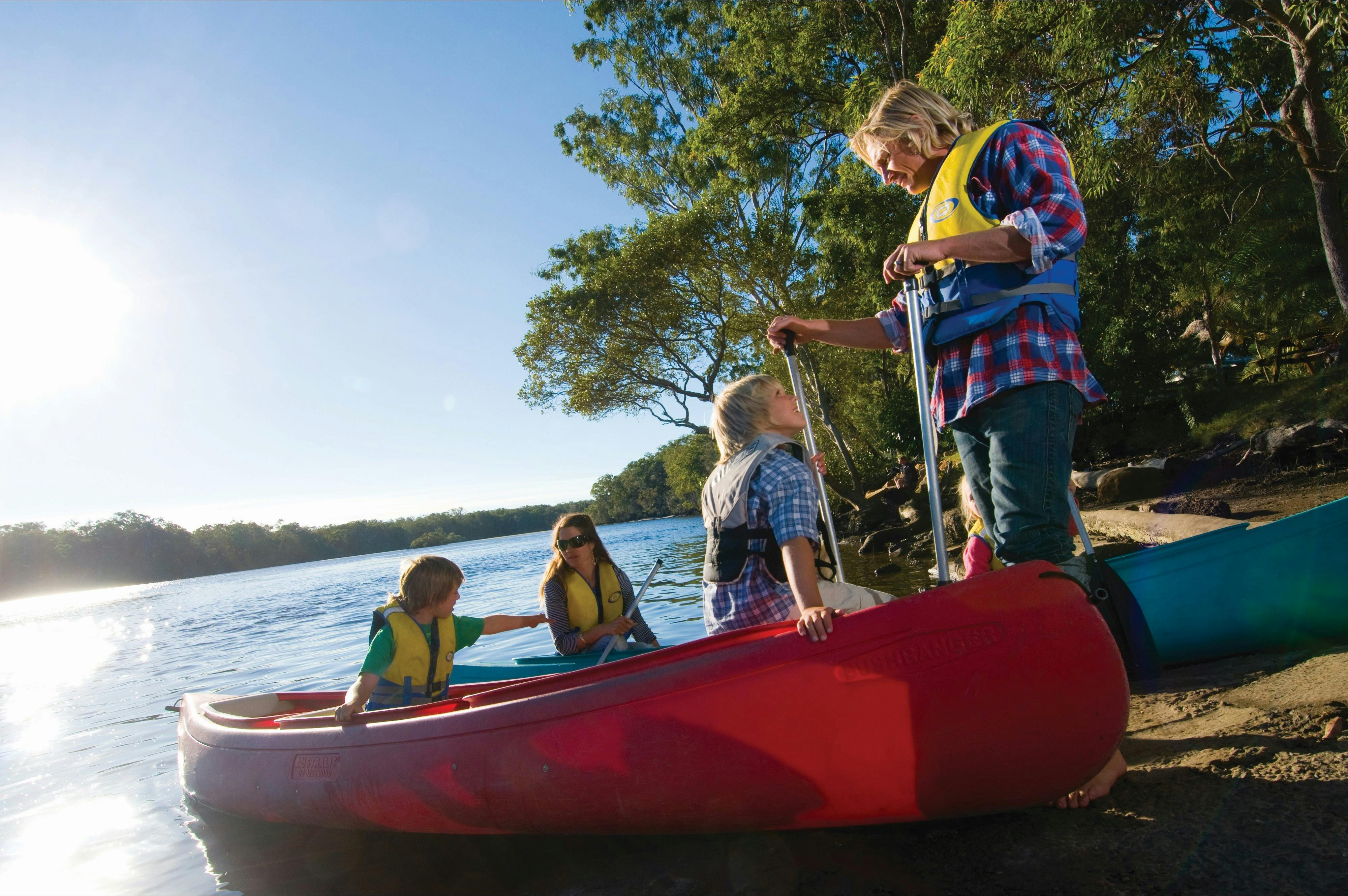 Canoes with people on river bank