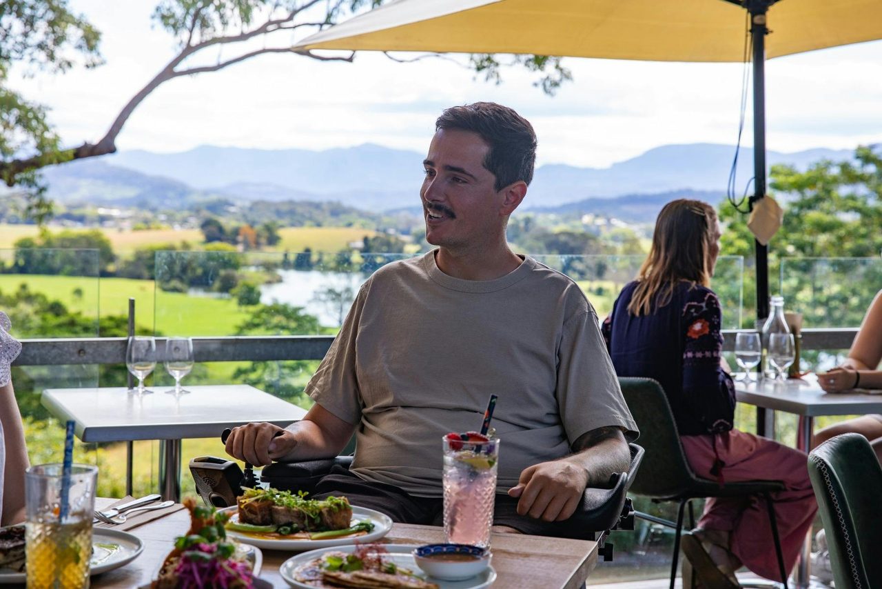Man in electric wheelchair enjoying lunch at Apex Dining in Murwillumbah