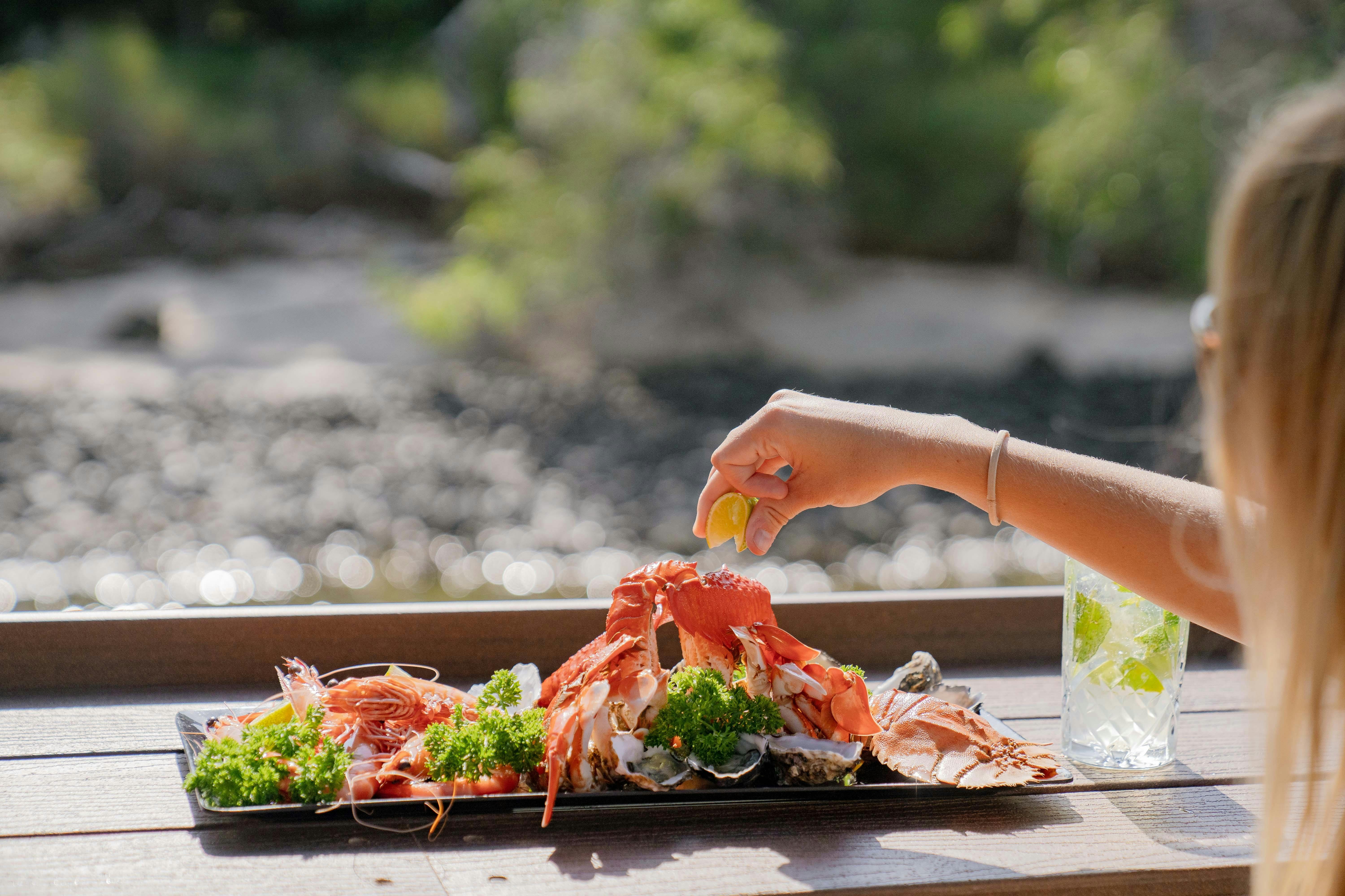 Person squeezing lime over seafood platter