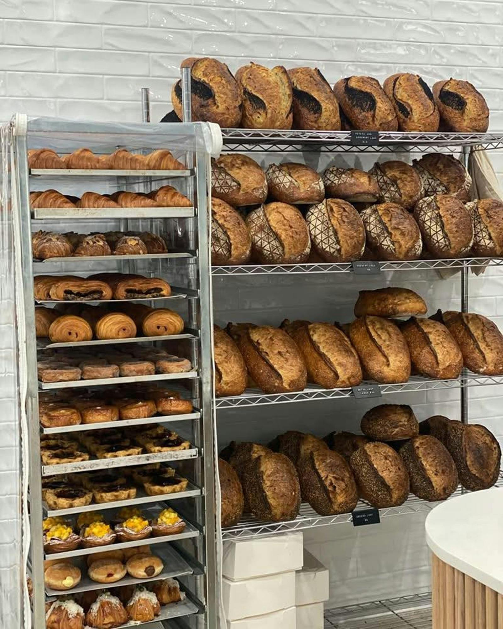 Racks of bread loaves and fridge of pastries