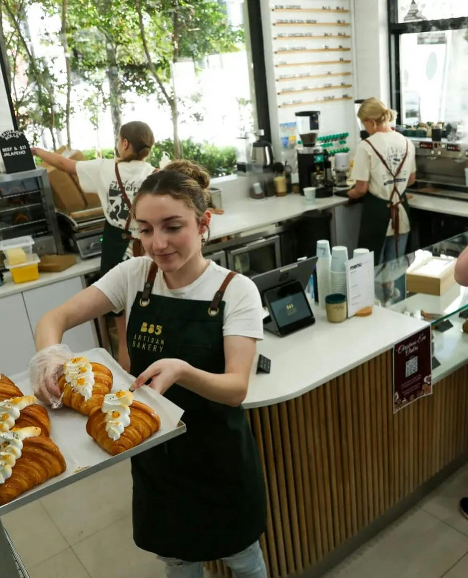 Bakers inside bakery attending to orders