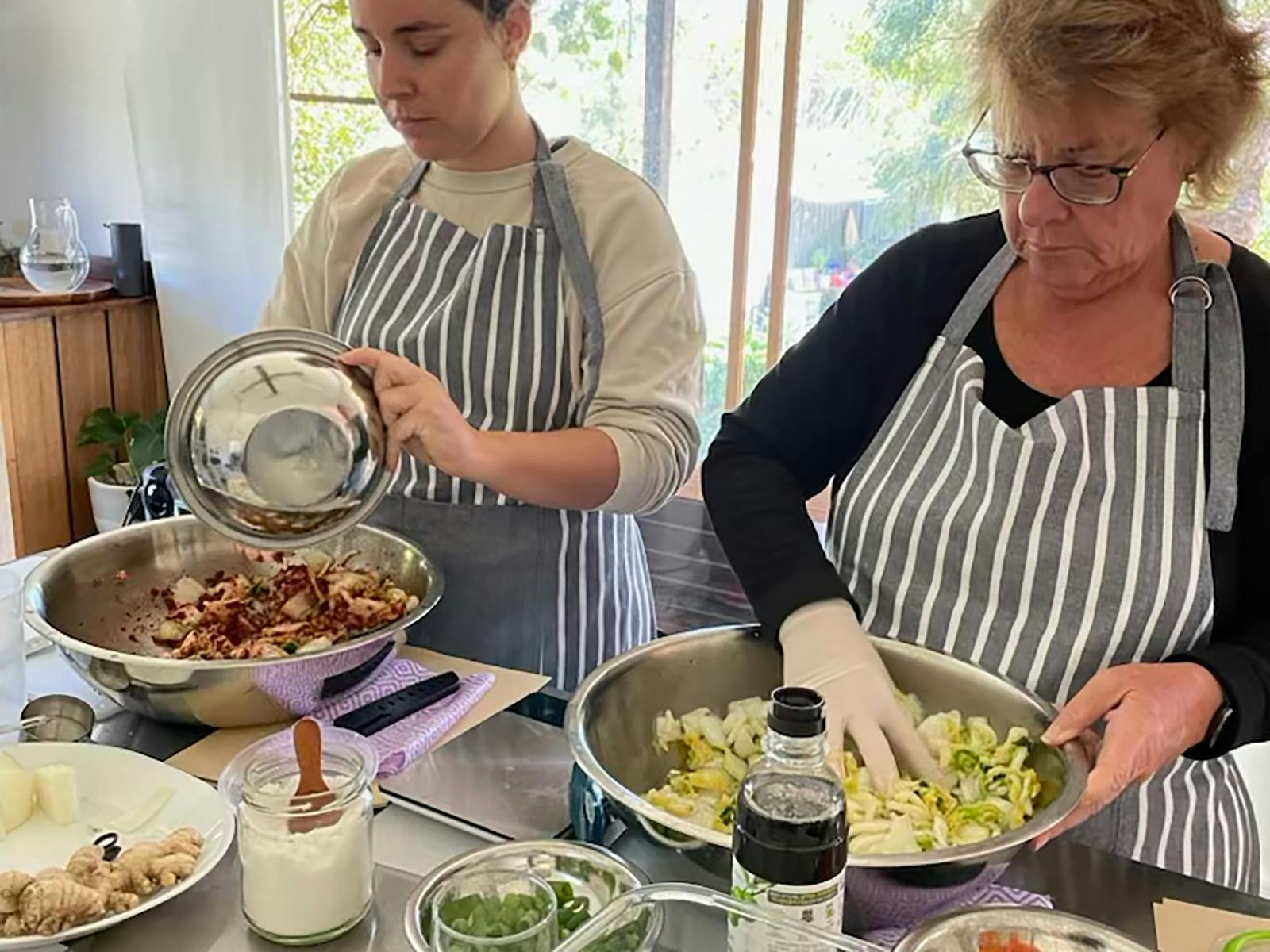 Workshop in progress, two women making kimchi