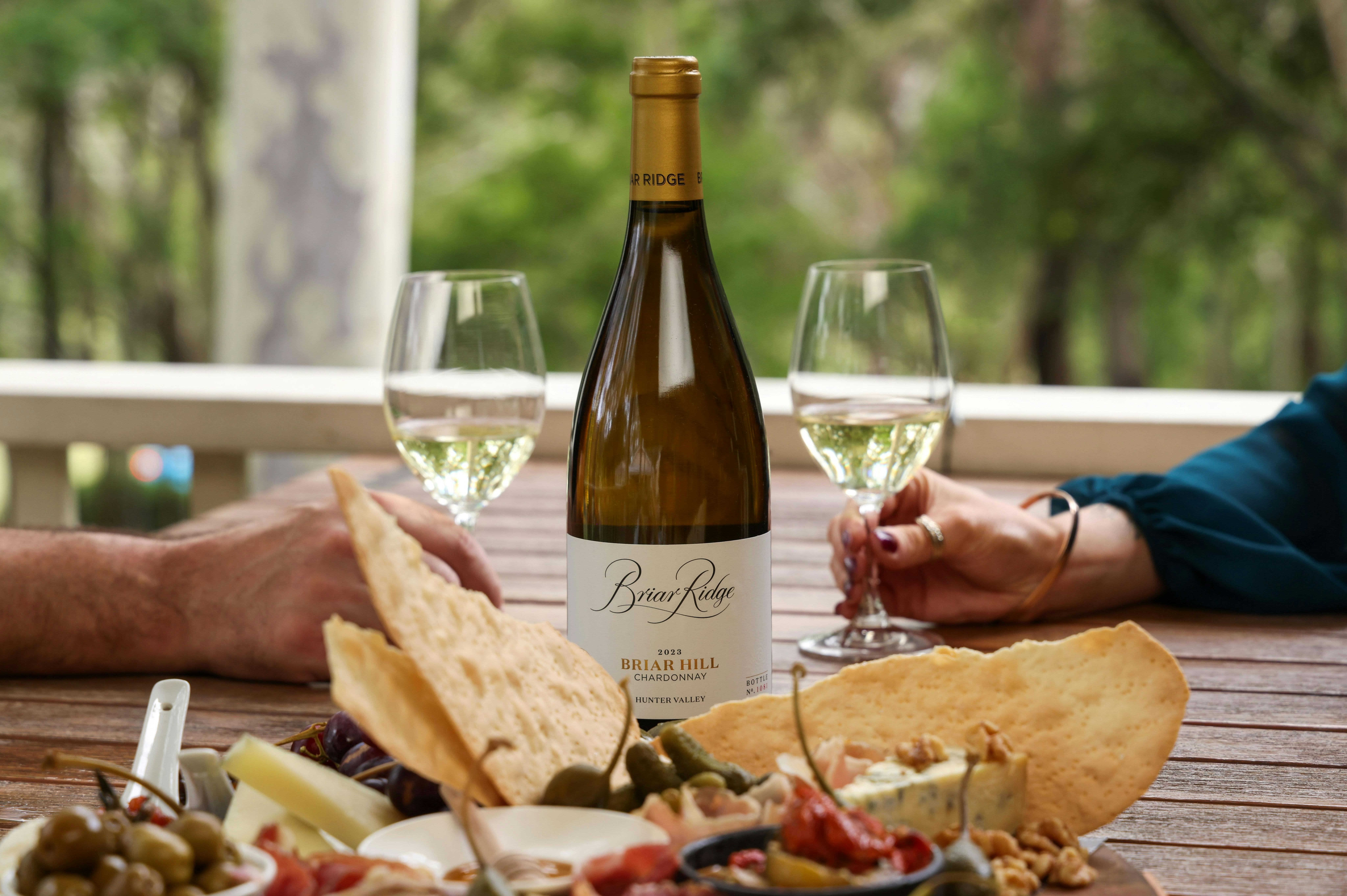 Two glasses of wine and a wine bottle behind a charcuterie board