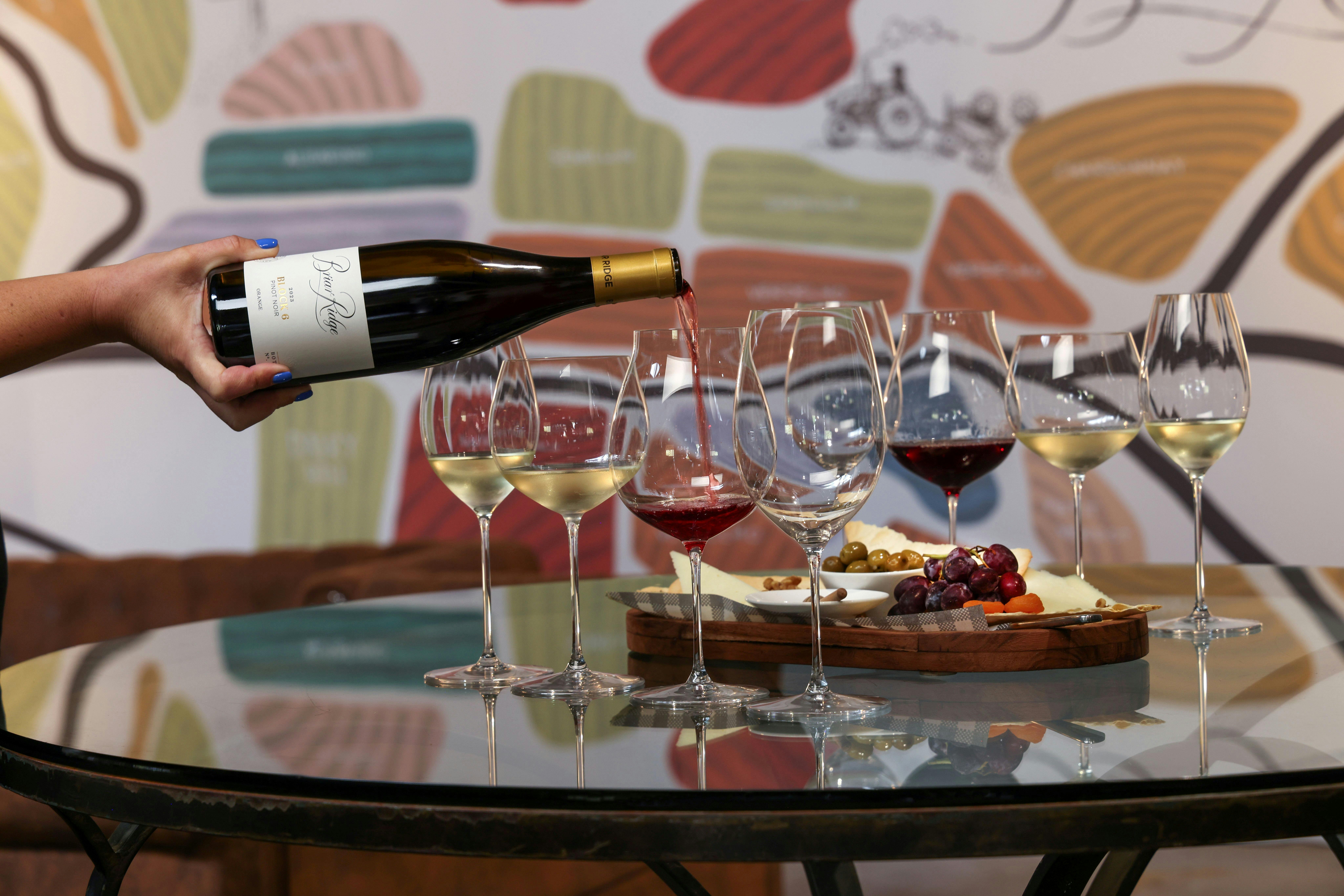 Wine being poured into glass with cheese board