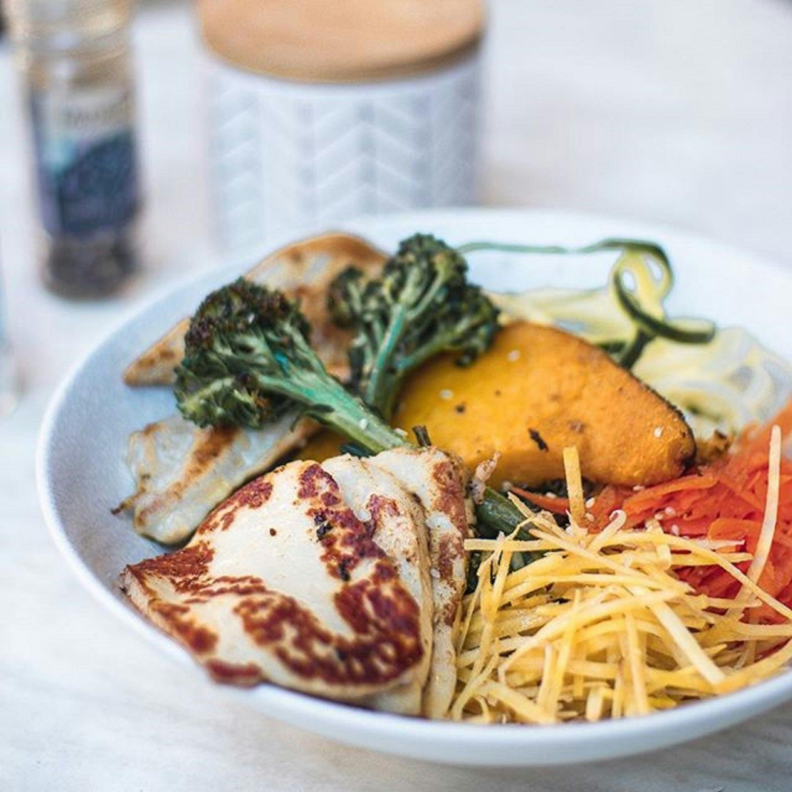 A bowl of breakfast foods such as grilled haloumi and broccoli