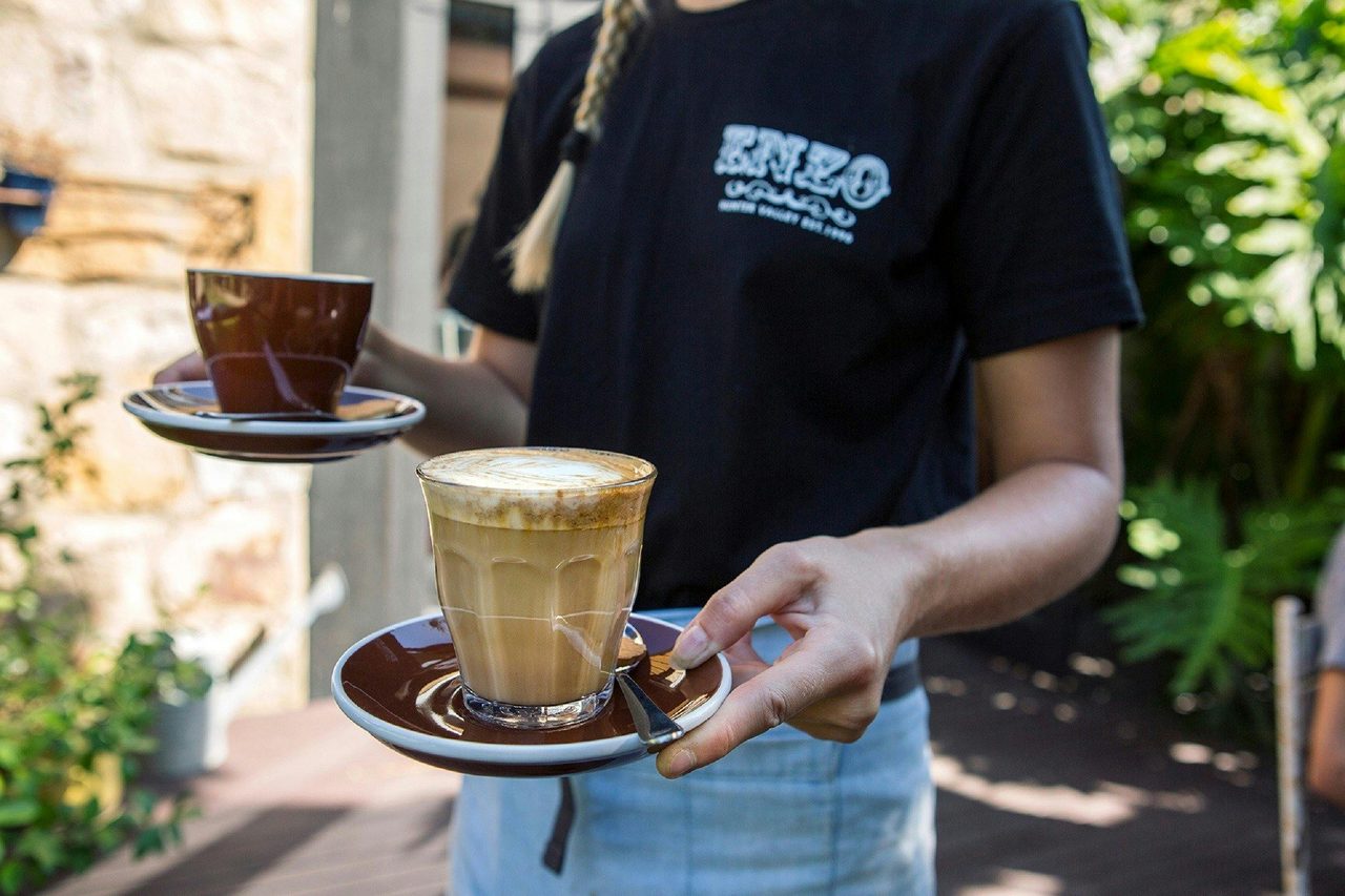 Waitress deliving morning coffees at Cafe Enzo, Pokolbin