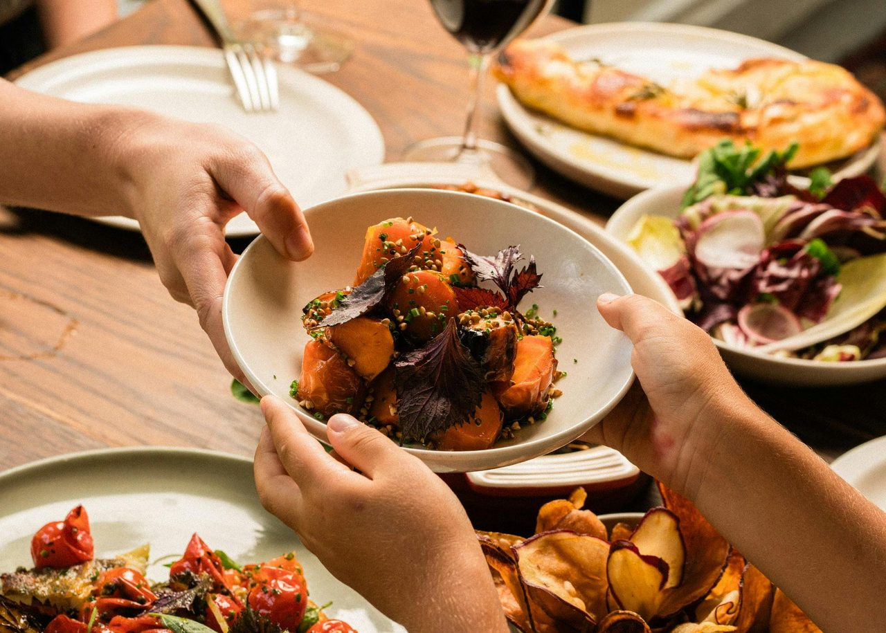 Hands passing plate of food