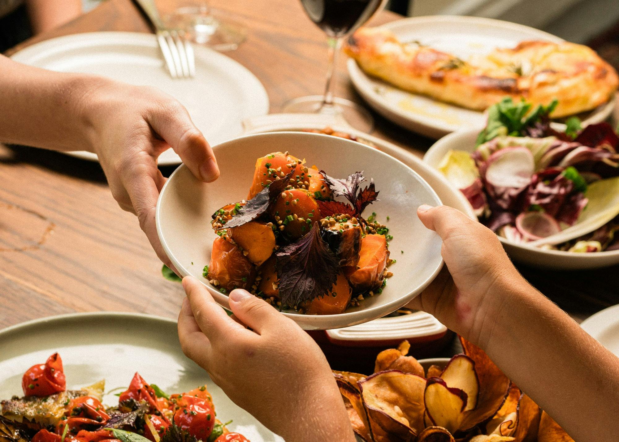 Hands passing plate of food
