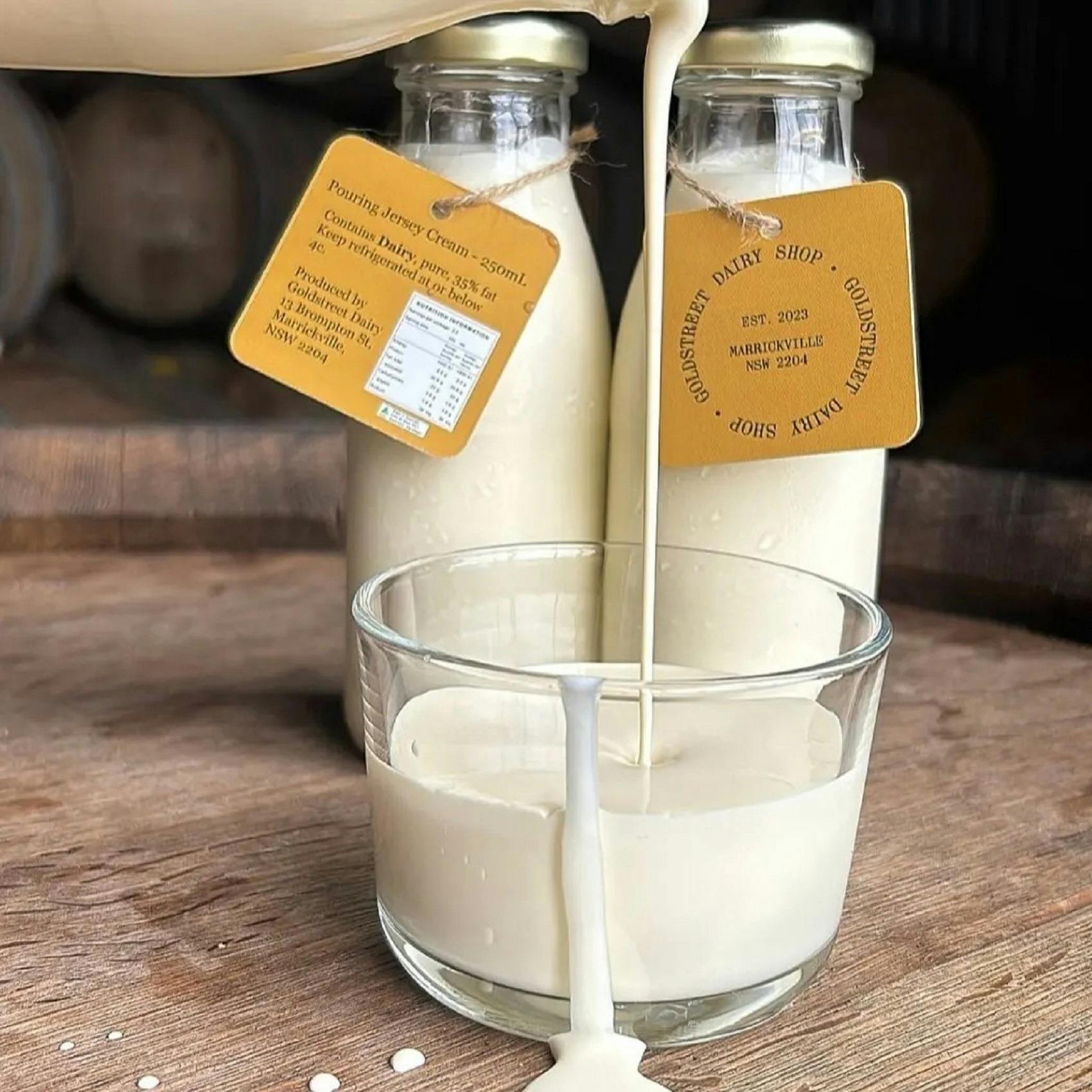 2 bottles of cream poring into a jug