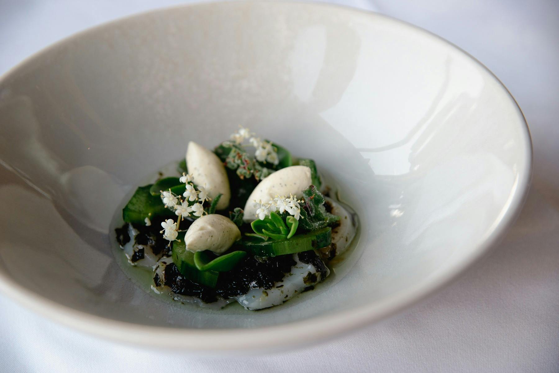 A beautifully presented plate of greens on a large white dish