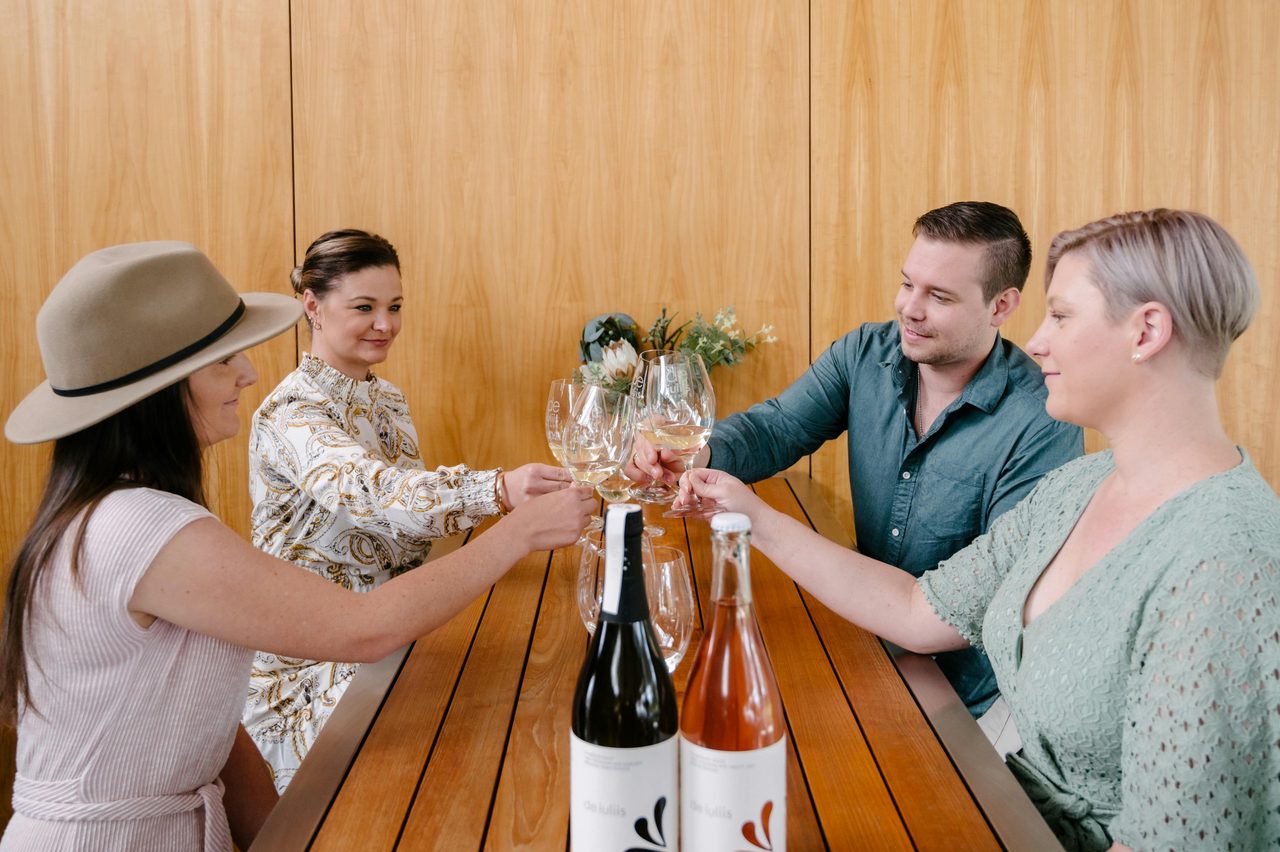 Cellar door guests cheers their wine glasses