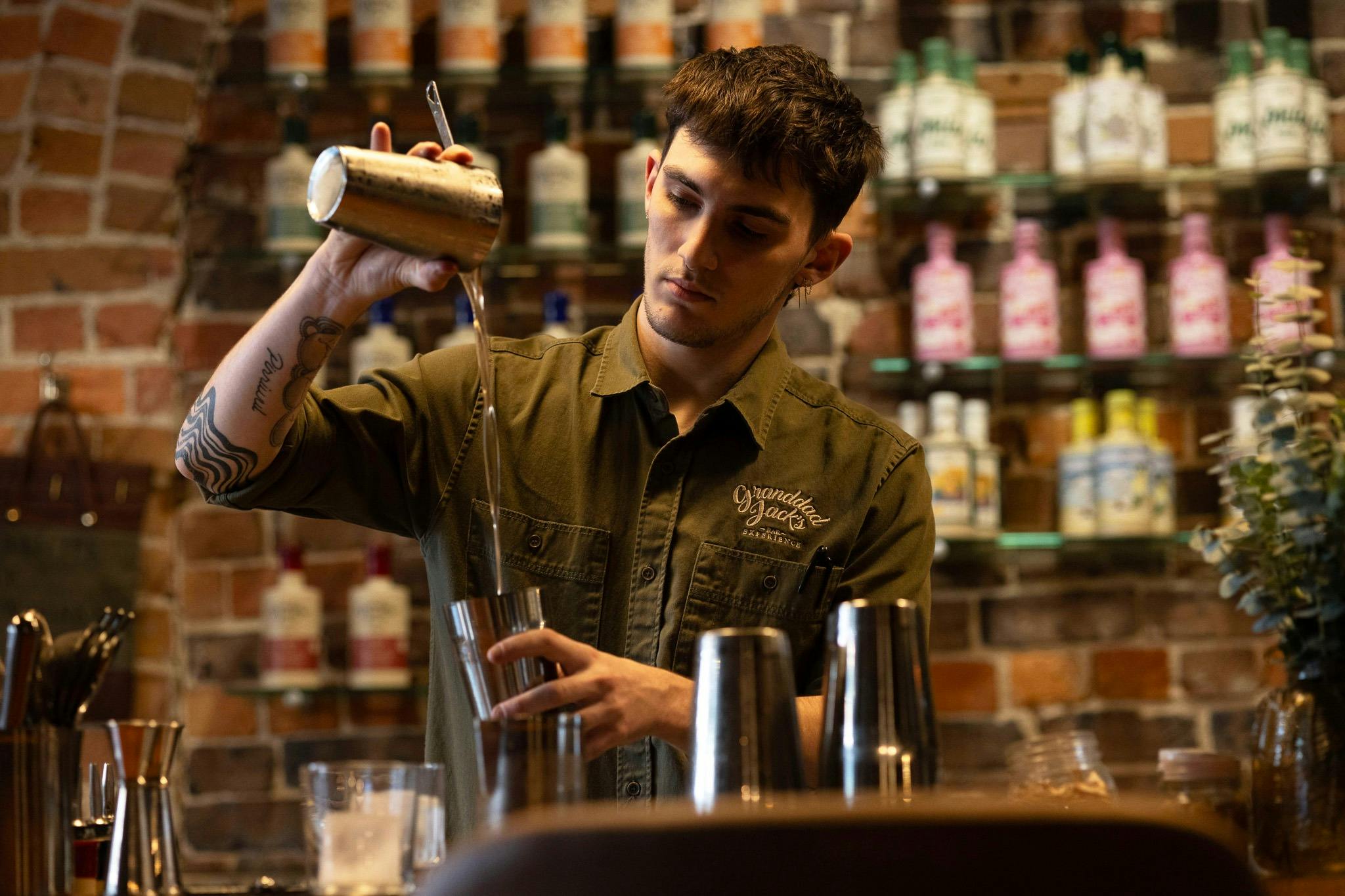 Hunter, a staff member at Granddad's Bar pouring a delicious and expertly crafted cocktail.