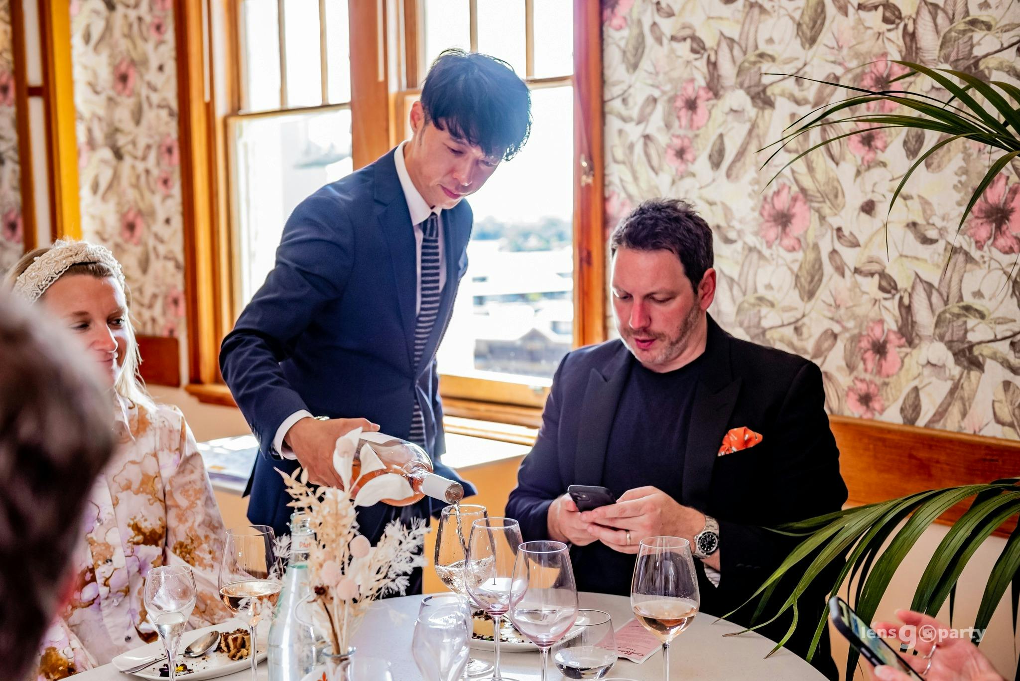 A waiter pours a patron a glass of red wine in the resturant