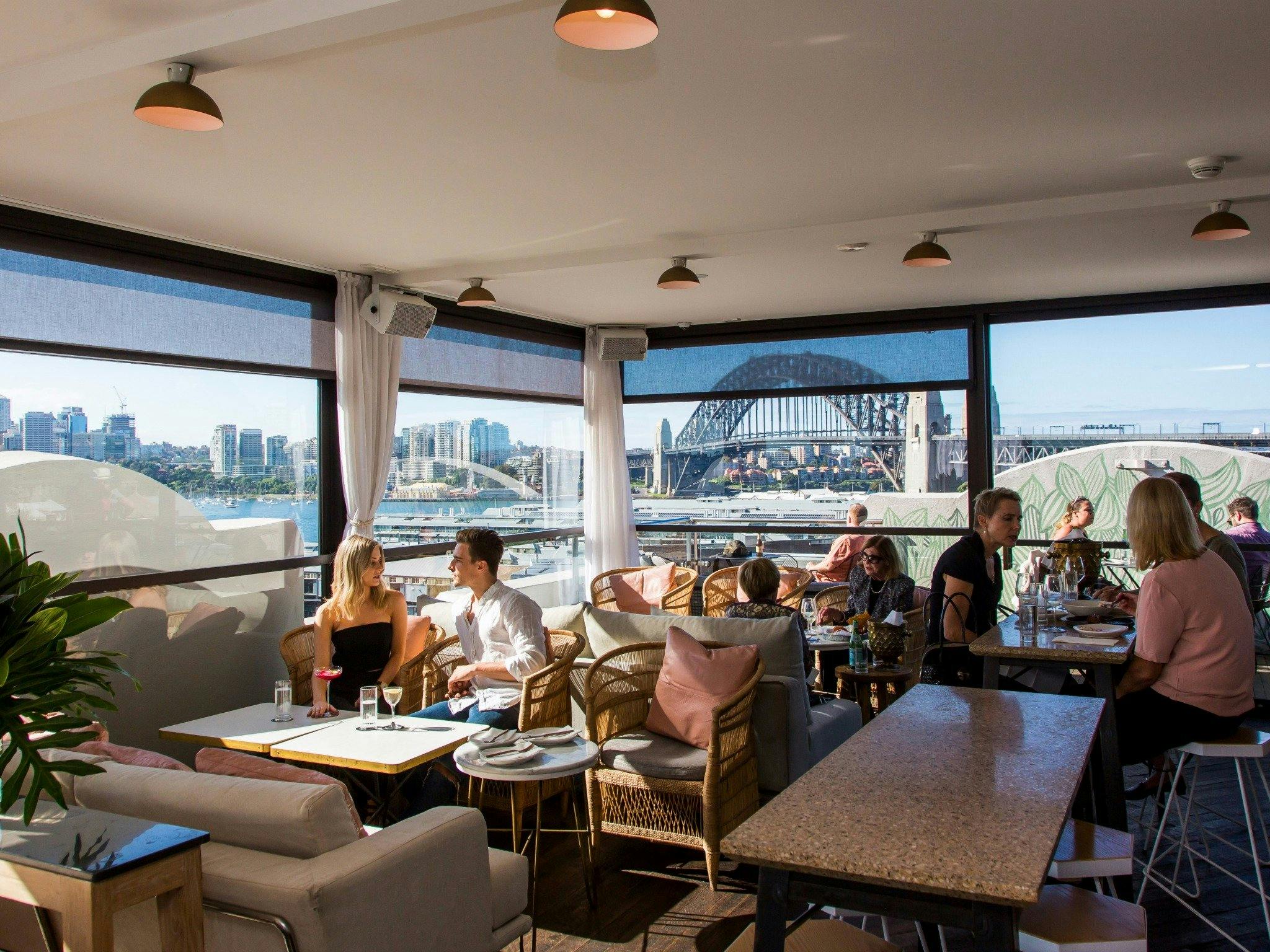 People enjoying food and drink at Henry Deane's rooftop cocktail lounge