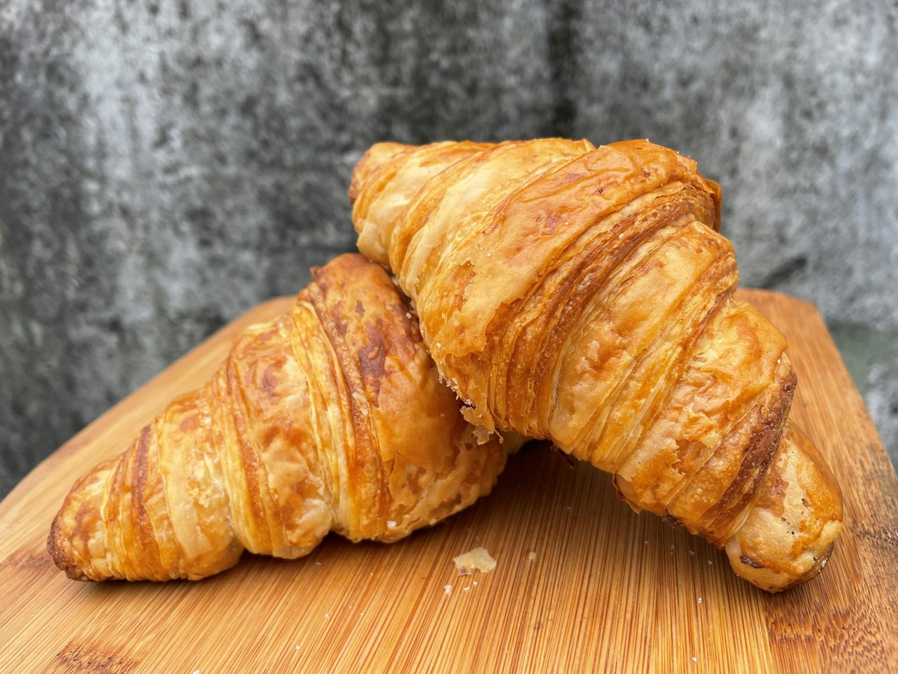 Two Real Butter Croissants on a wooden board