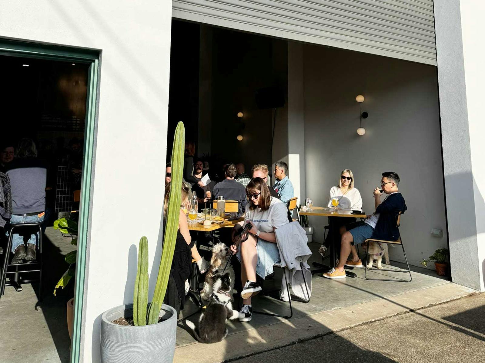 People enjoying beers inside the Kicks Brewing taproom on a sunny afternoon