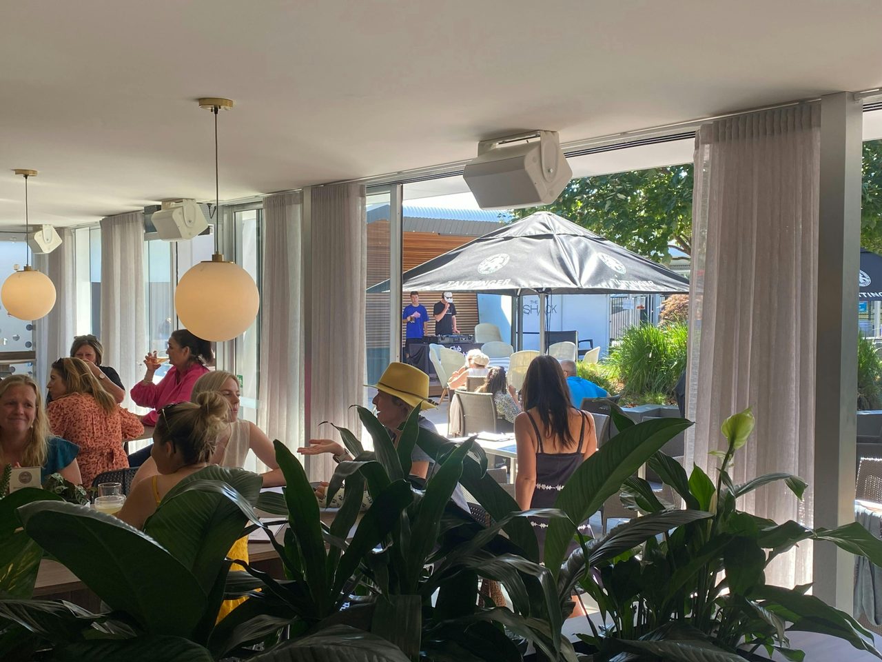 Indoor/outdoor dining area with DJ playing in the courtyard