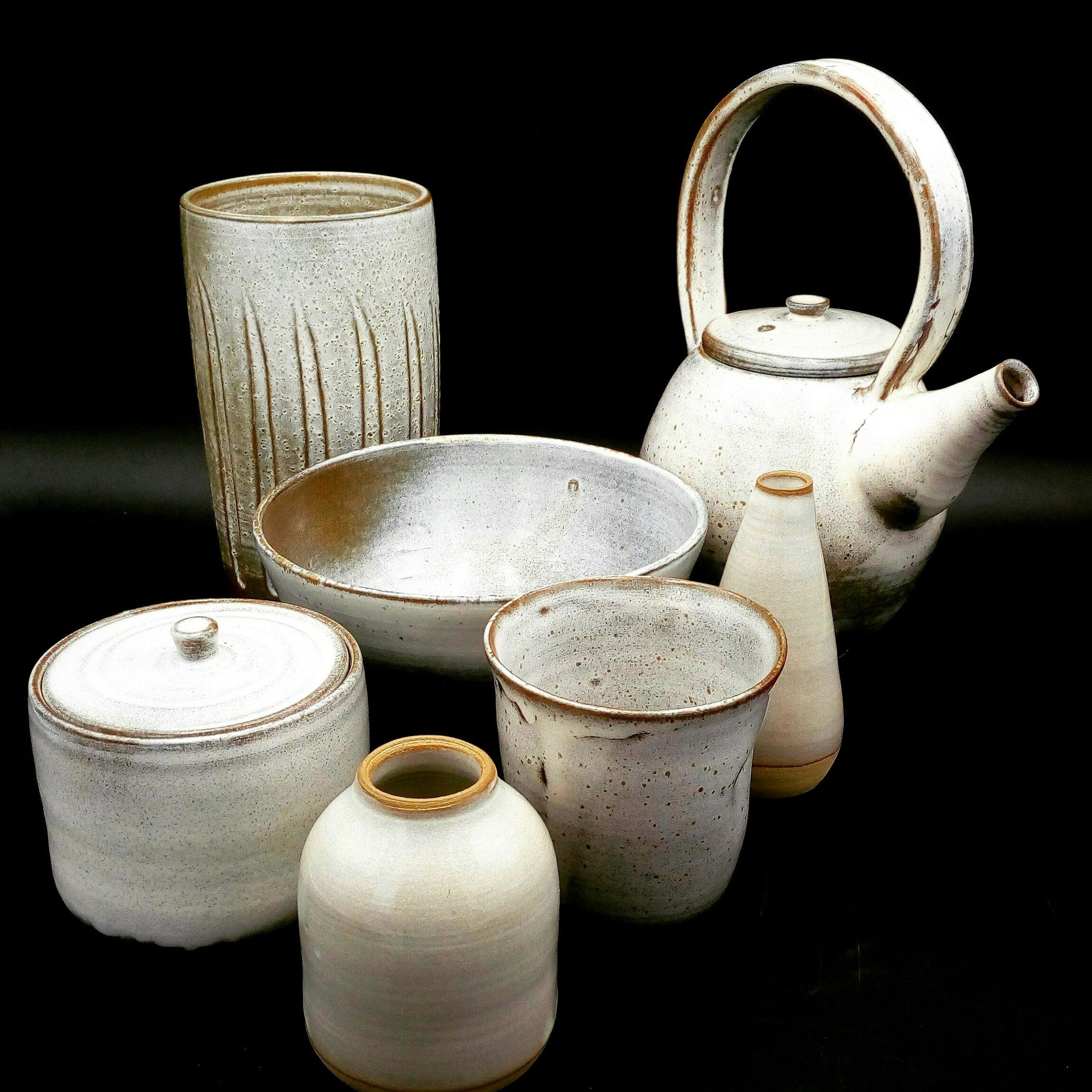 Set of white handmade ceramic tableware items.