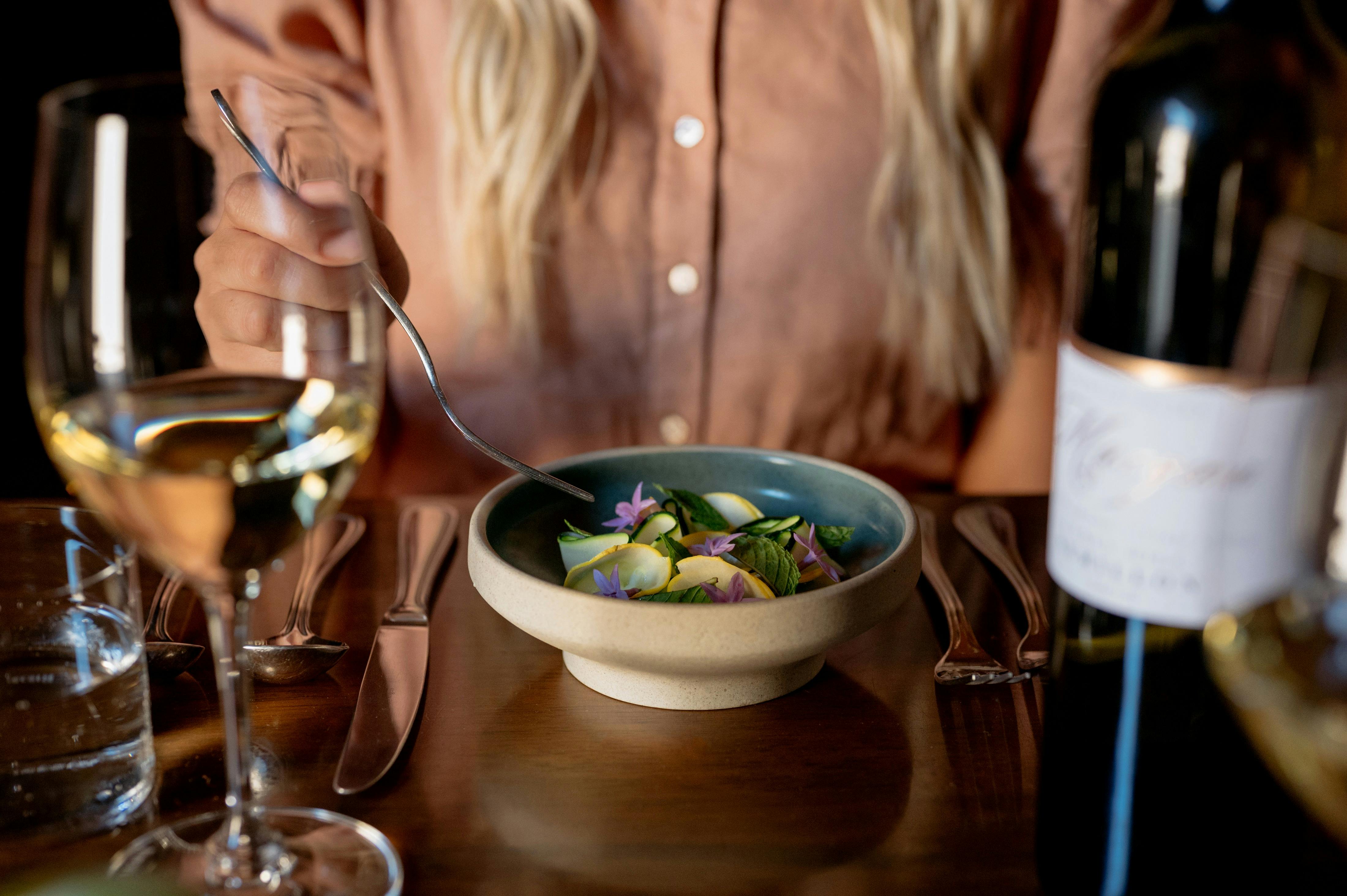 Guest enjoys a house made entree and Margan White Label wine in our restaurant