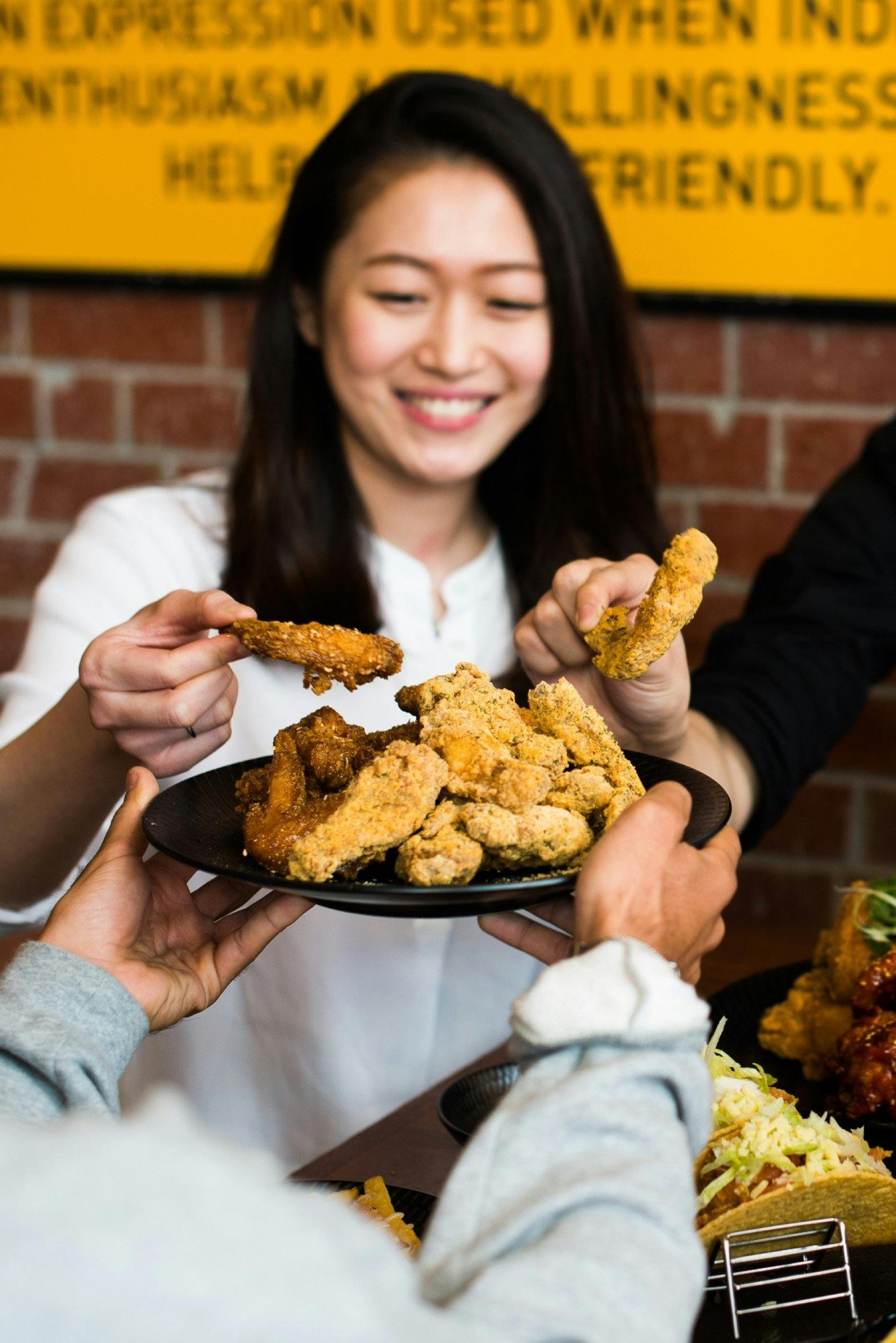 Girl holding a piece of korean fried chicken