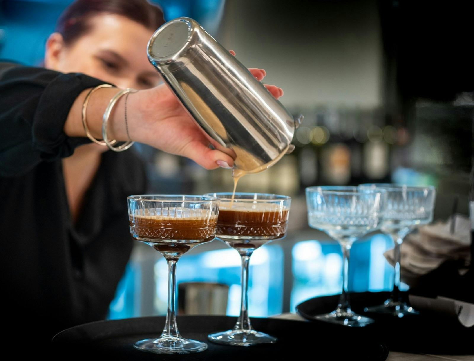 A lady preparing martinis