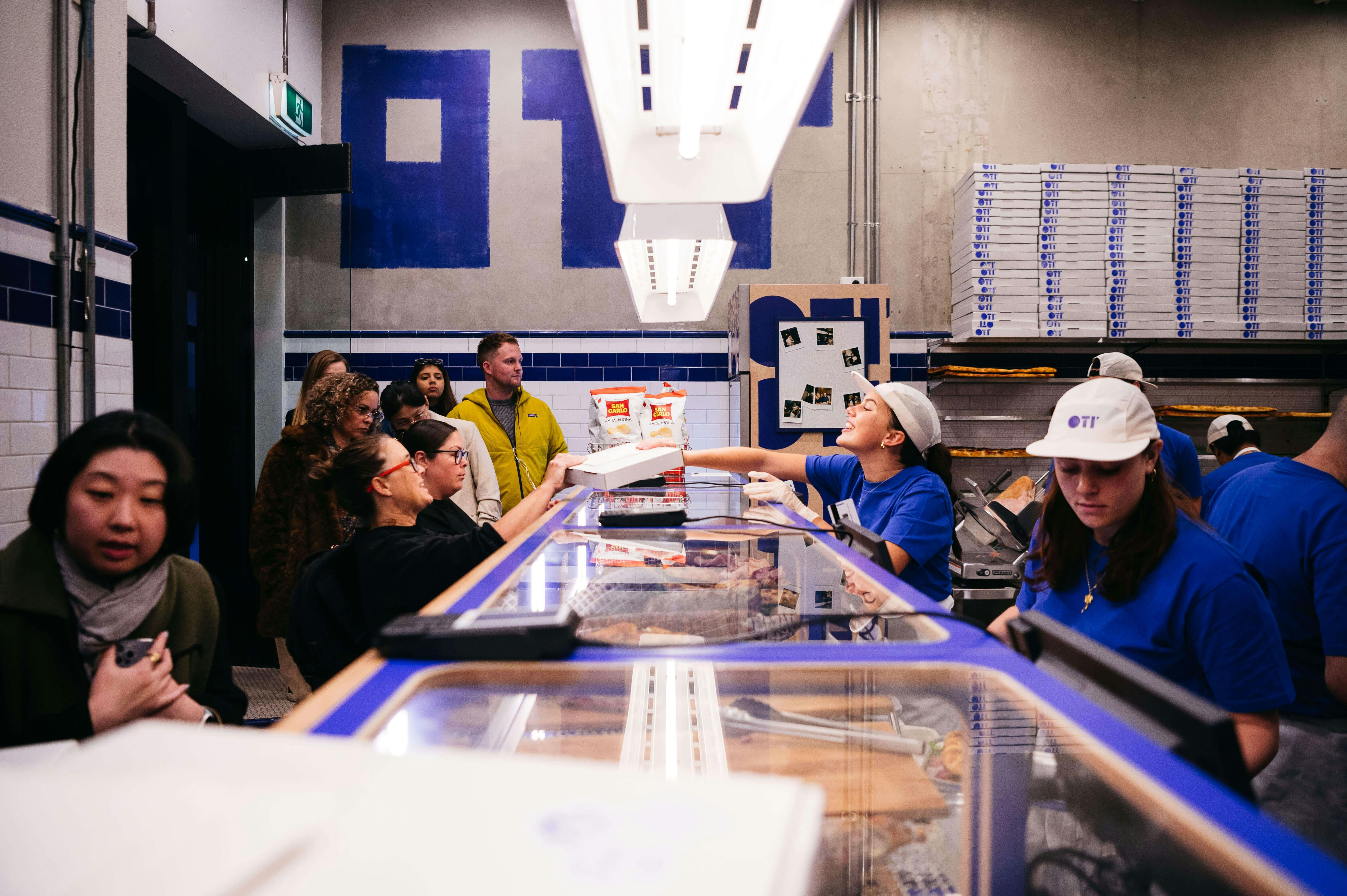 Customers ordering pizza inside the store