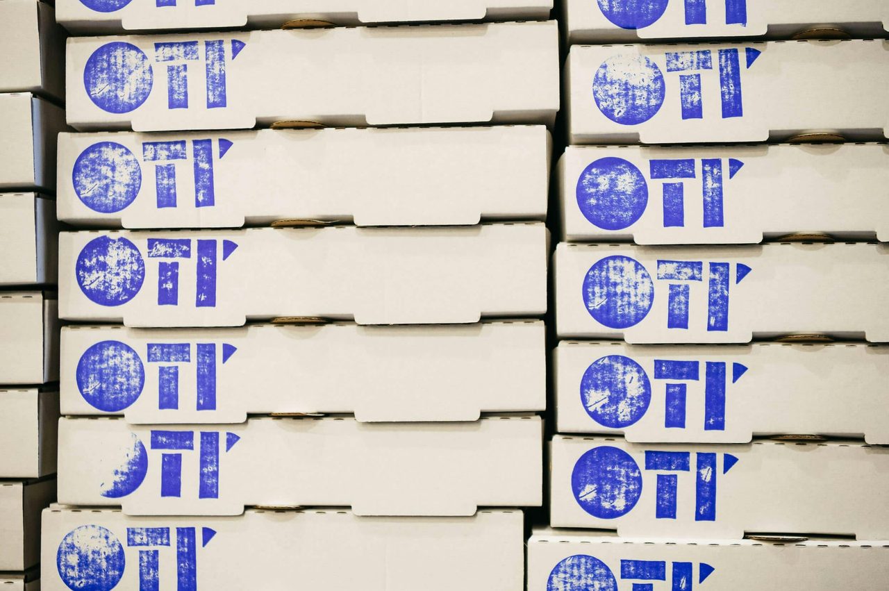 Stacked Oti' pizza boxes