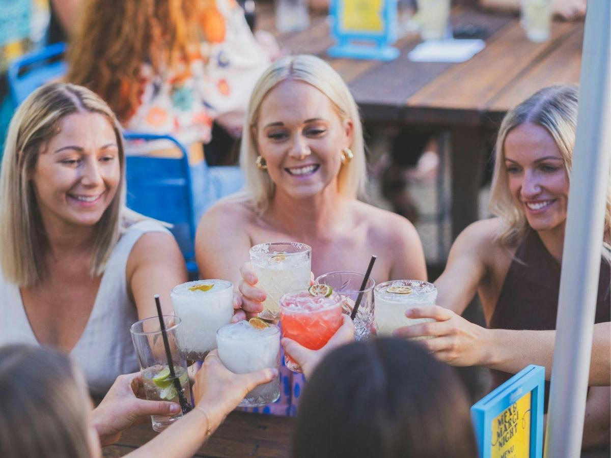 Group of ladies with cocktails saying 'Cheers!'