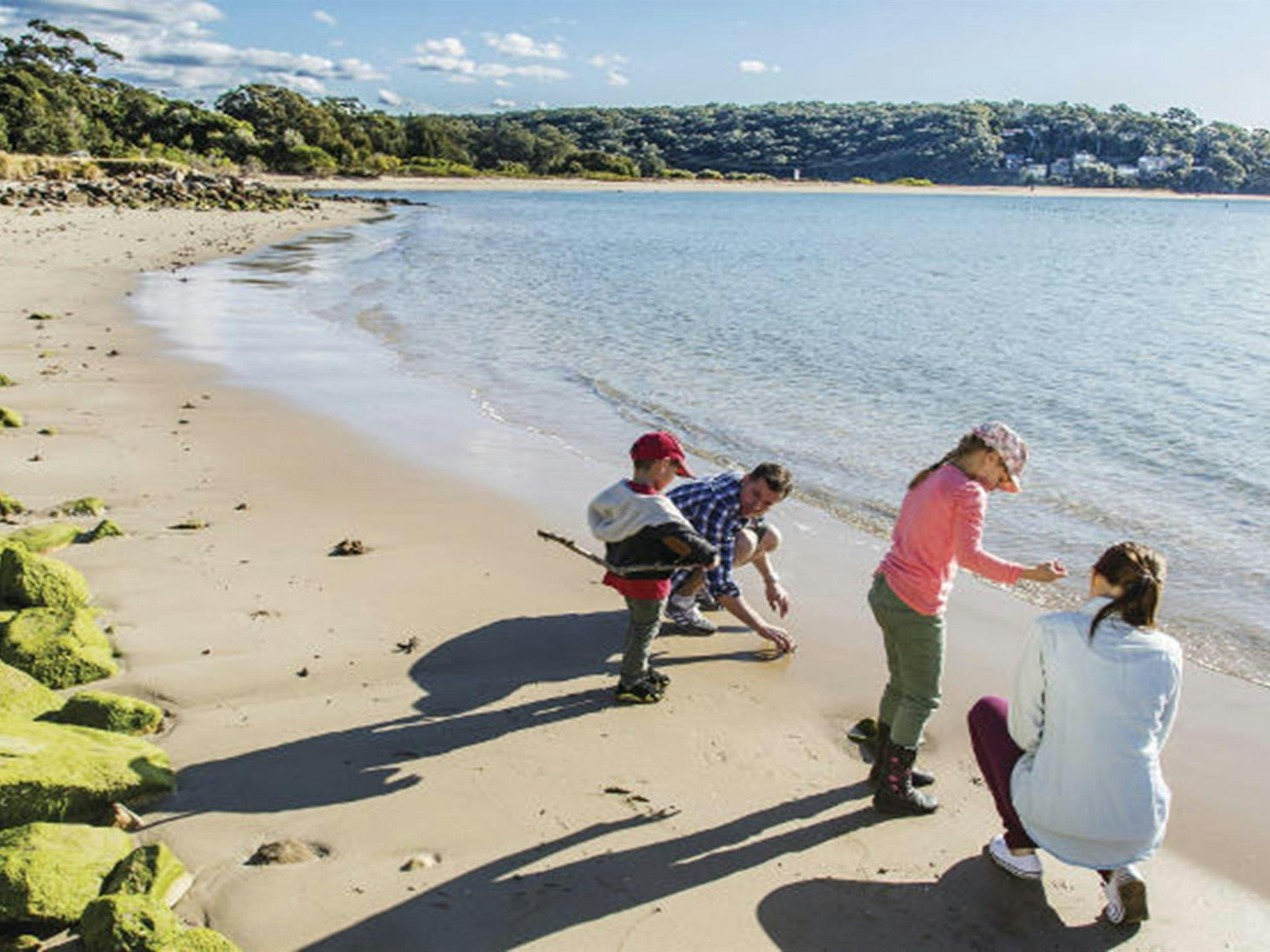 A family takes a walk along the beach next to Bonnie Vale picnic area in Royal National Park. Photo: