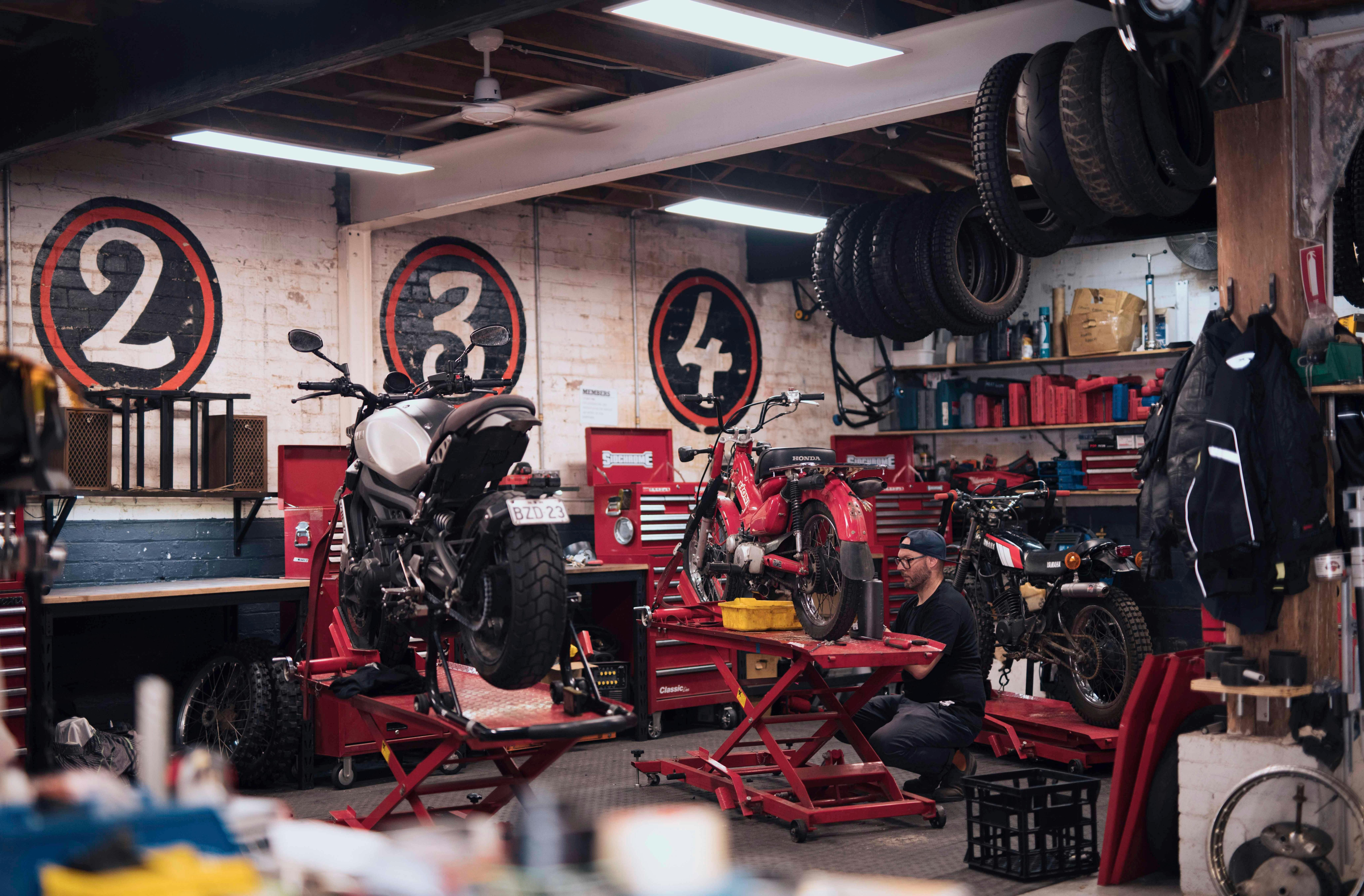 Man working on his motorcycle at the Rising Sun Workshop