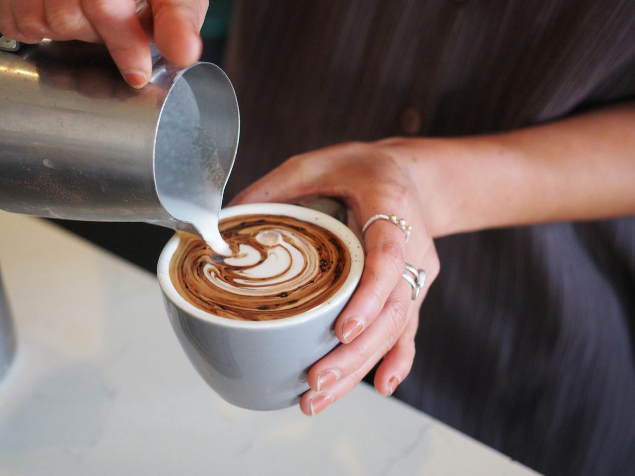 Staff making a milk coffee at Sample Coffee.