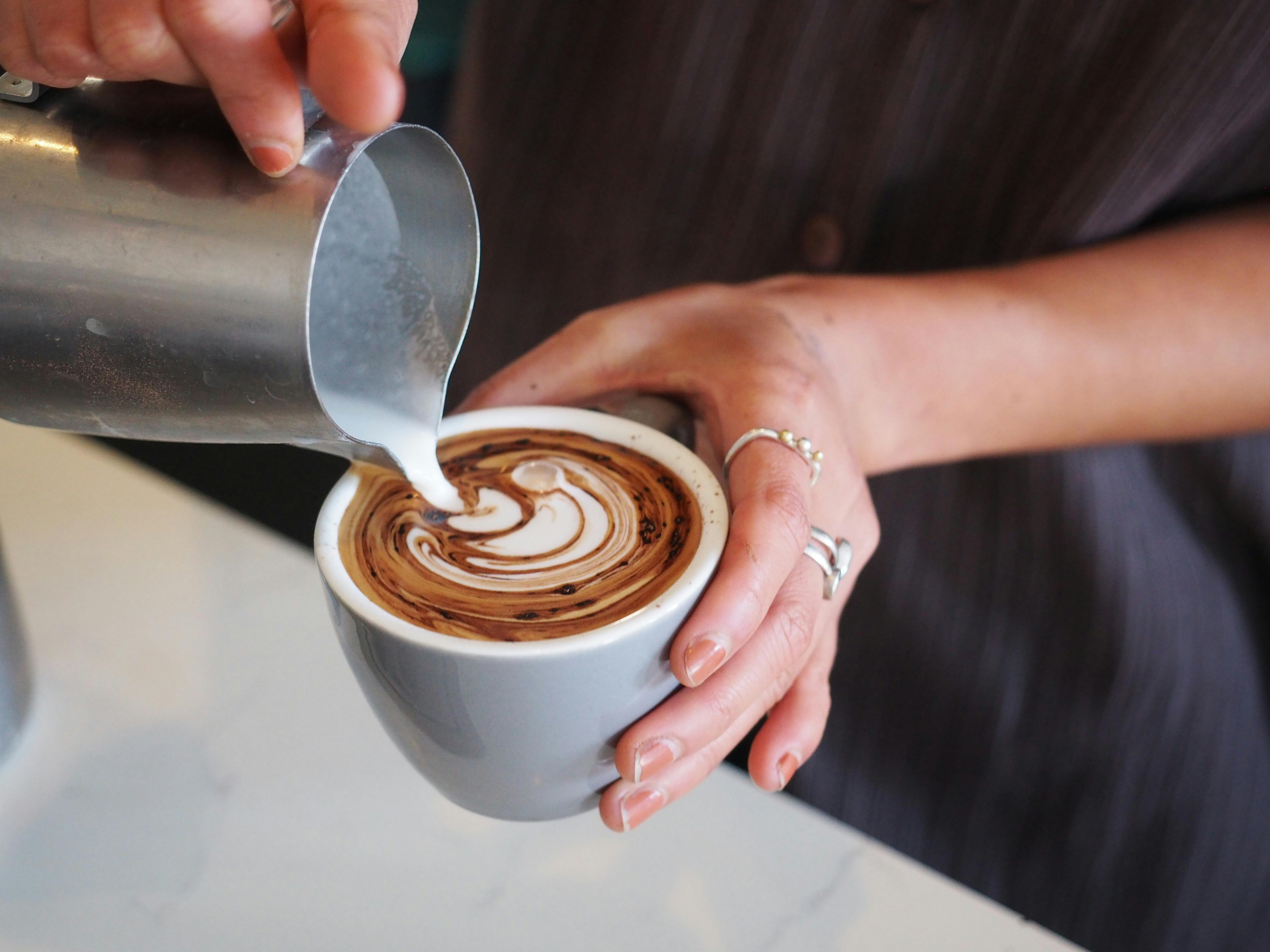 Staff making a milk coffee at Sample Coffee.